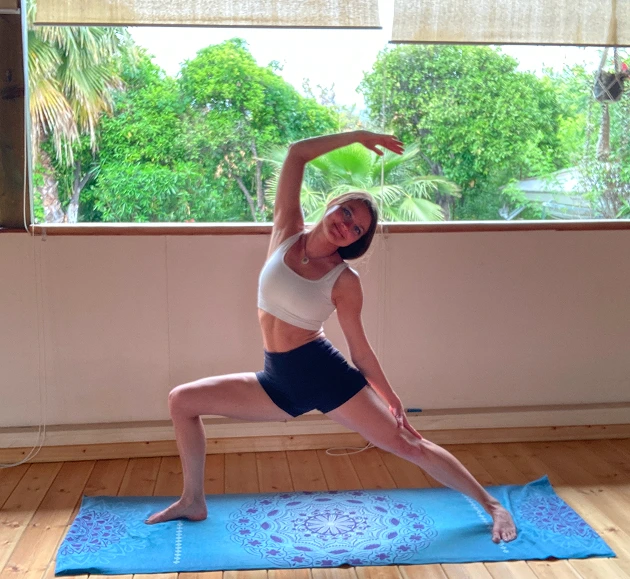 Tati in the yoga shala in Reverse Warrior pose