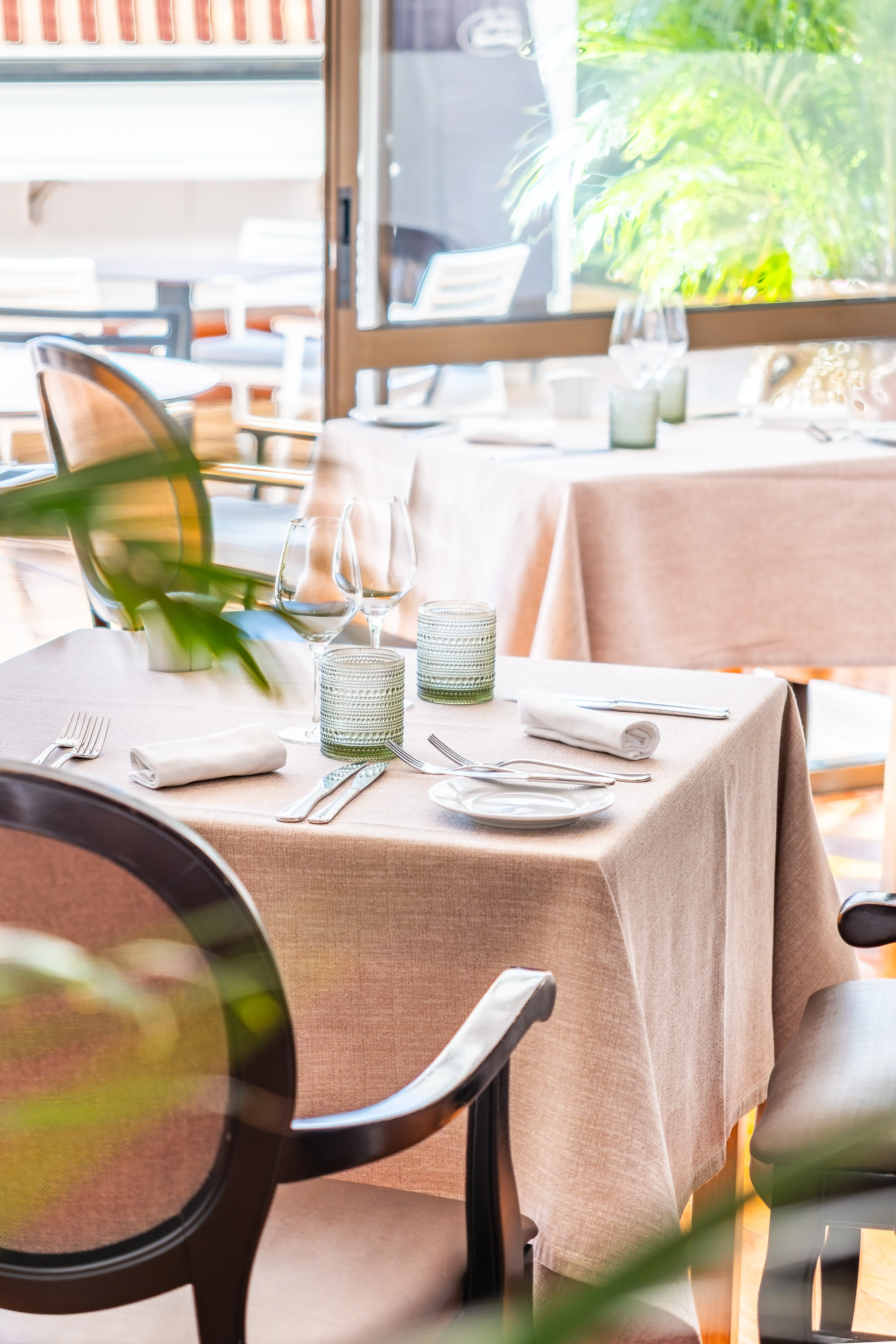 Ambiente de restaurante com mesa preparada e têxteis cuidadosamente tratados.