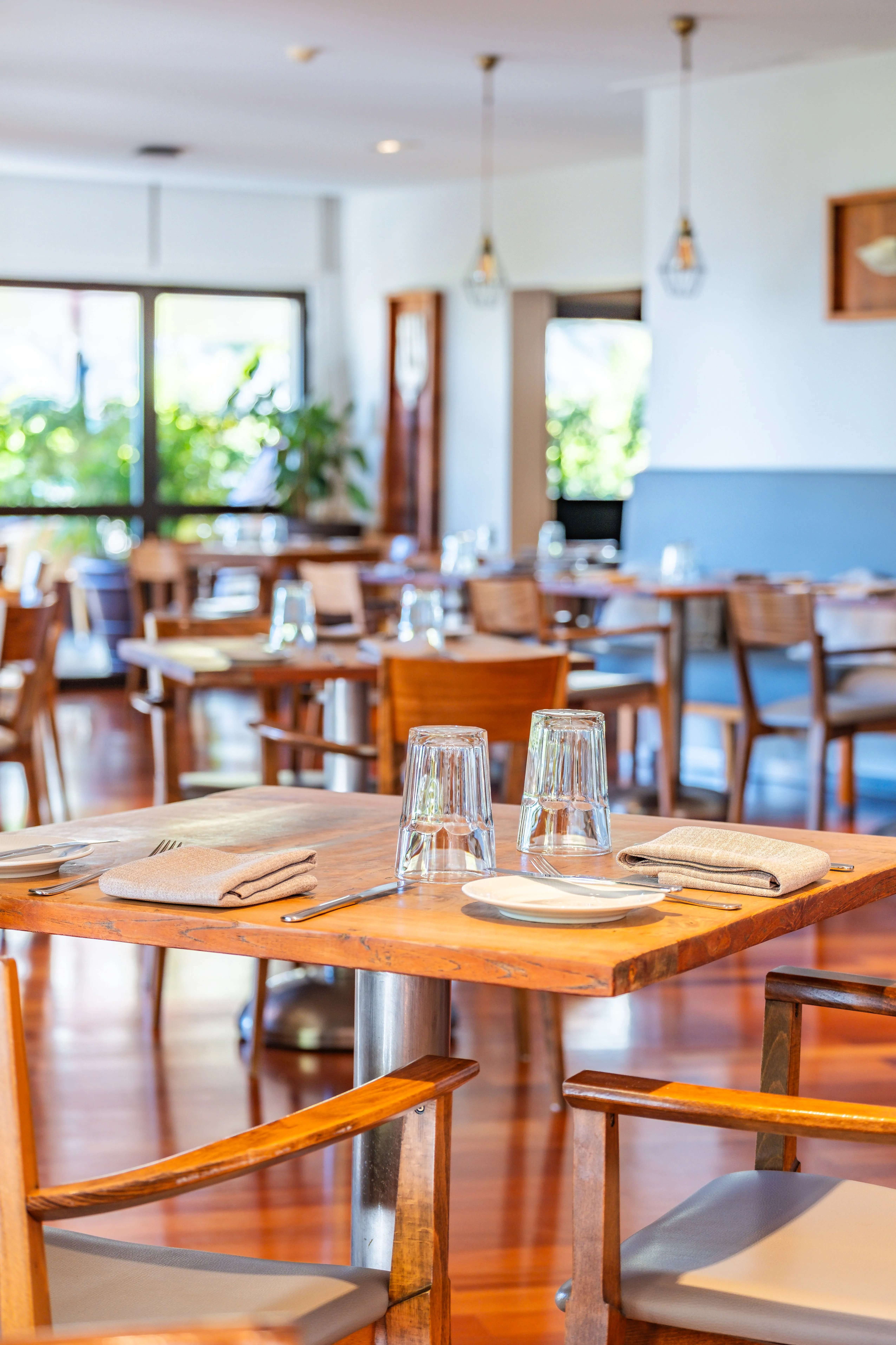 Espaço de restauração com mesas postas e têxteis impecáveis, pronto para receber clientes.