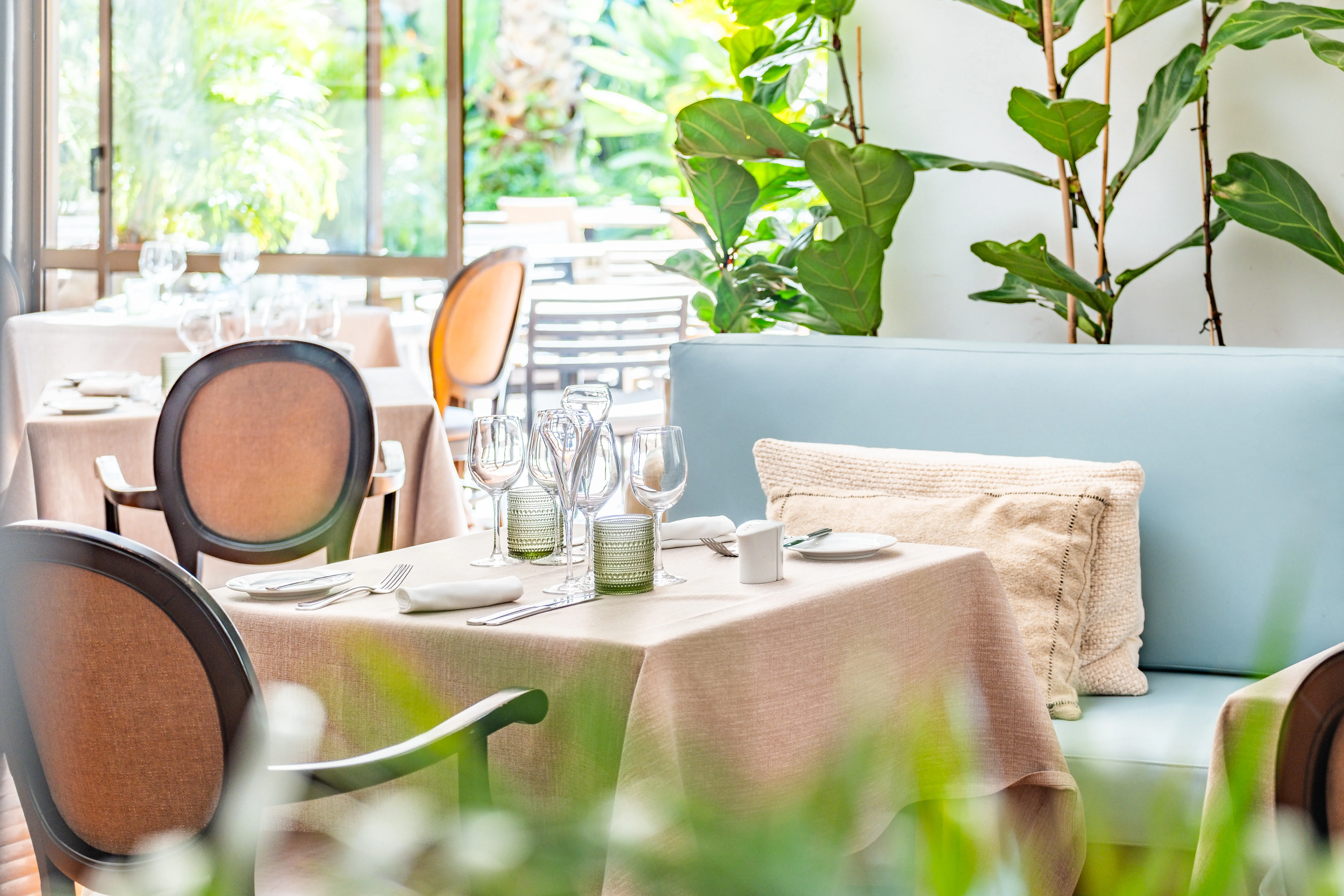 Sala de restaurante preparada para receber clientes, com foco no detalhe e na apresentação têxtil.