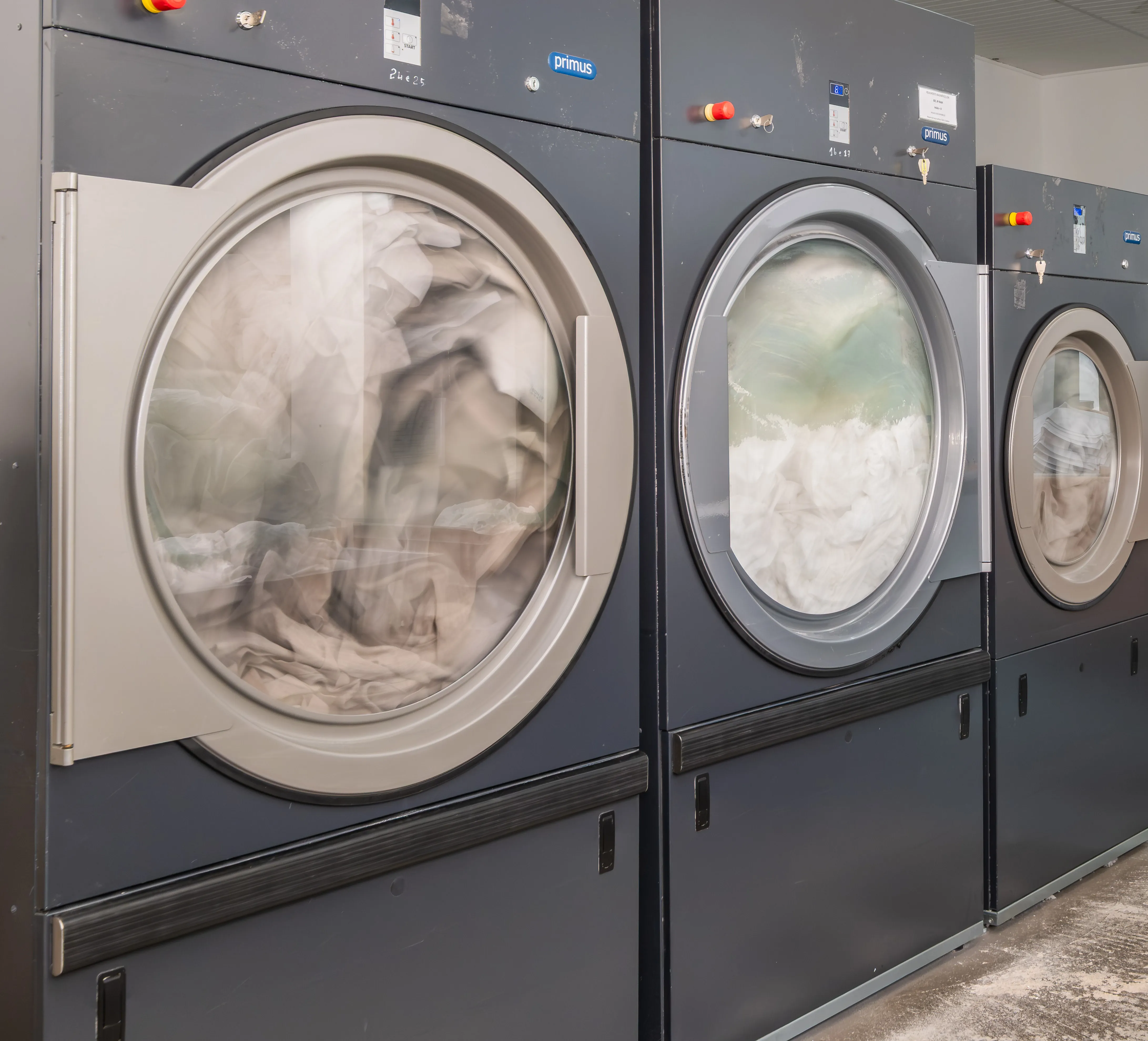 Equipamentos industriais de lavagem da lavandaria profissional Mãos à Roupa em funcionamento.