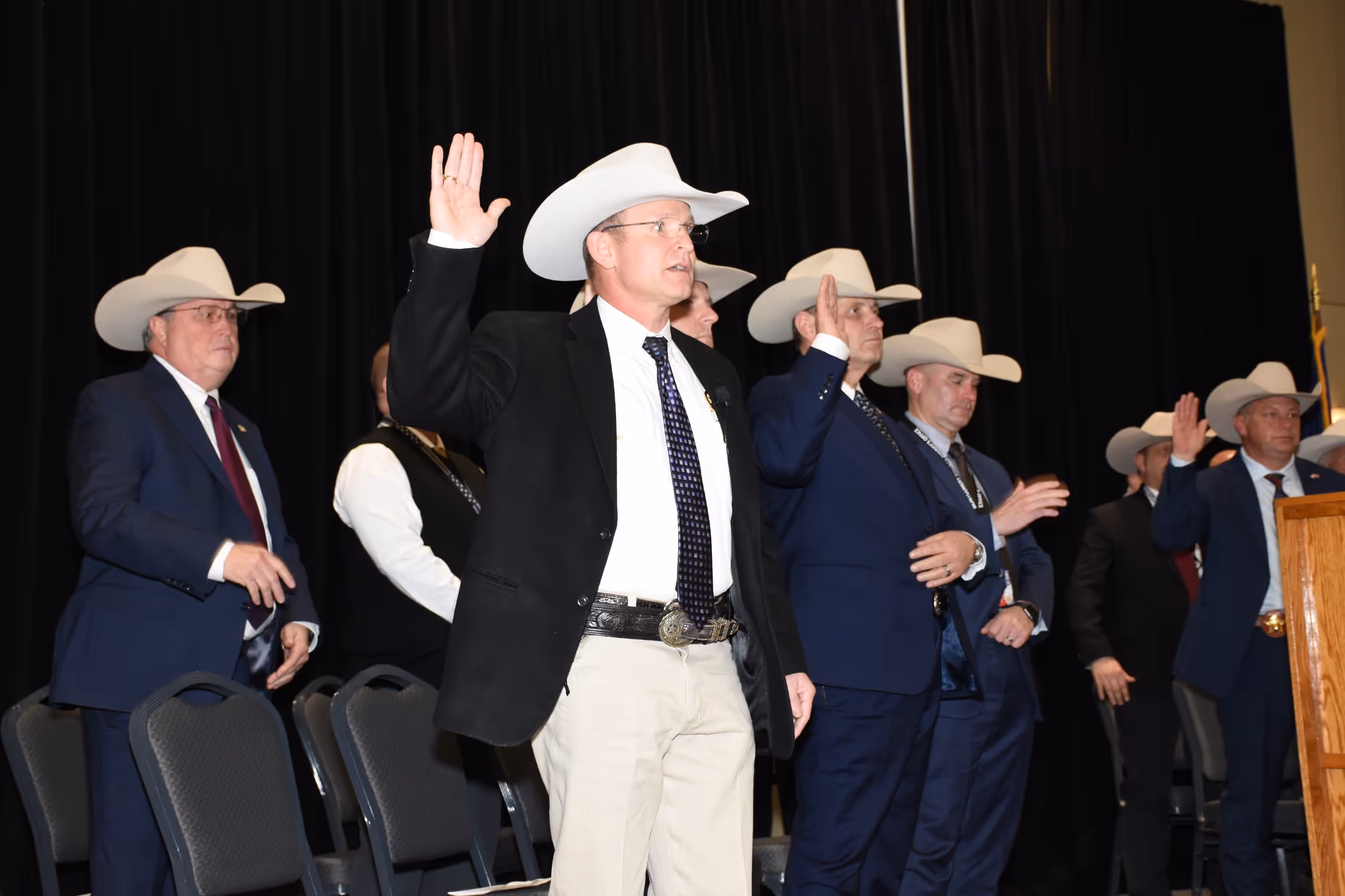 Montgomery County law enforcement leaders raising their right hands during an oath ceremony on stage