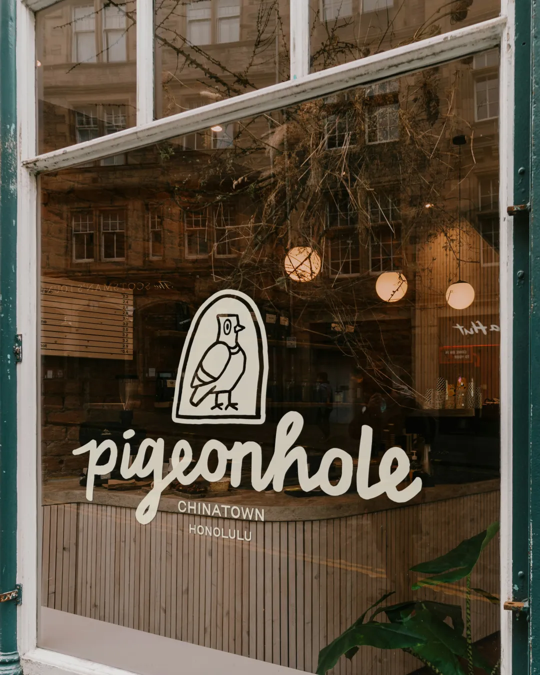 Open brand guideline booklet showing a colour palette with terracotta, blue, off white, black, and white colors, alongside social media design elements including a phone screen mockup and logo.