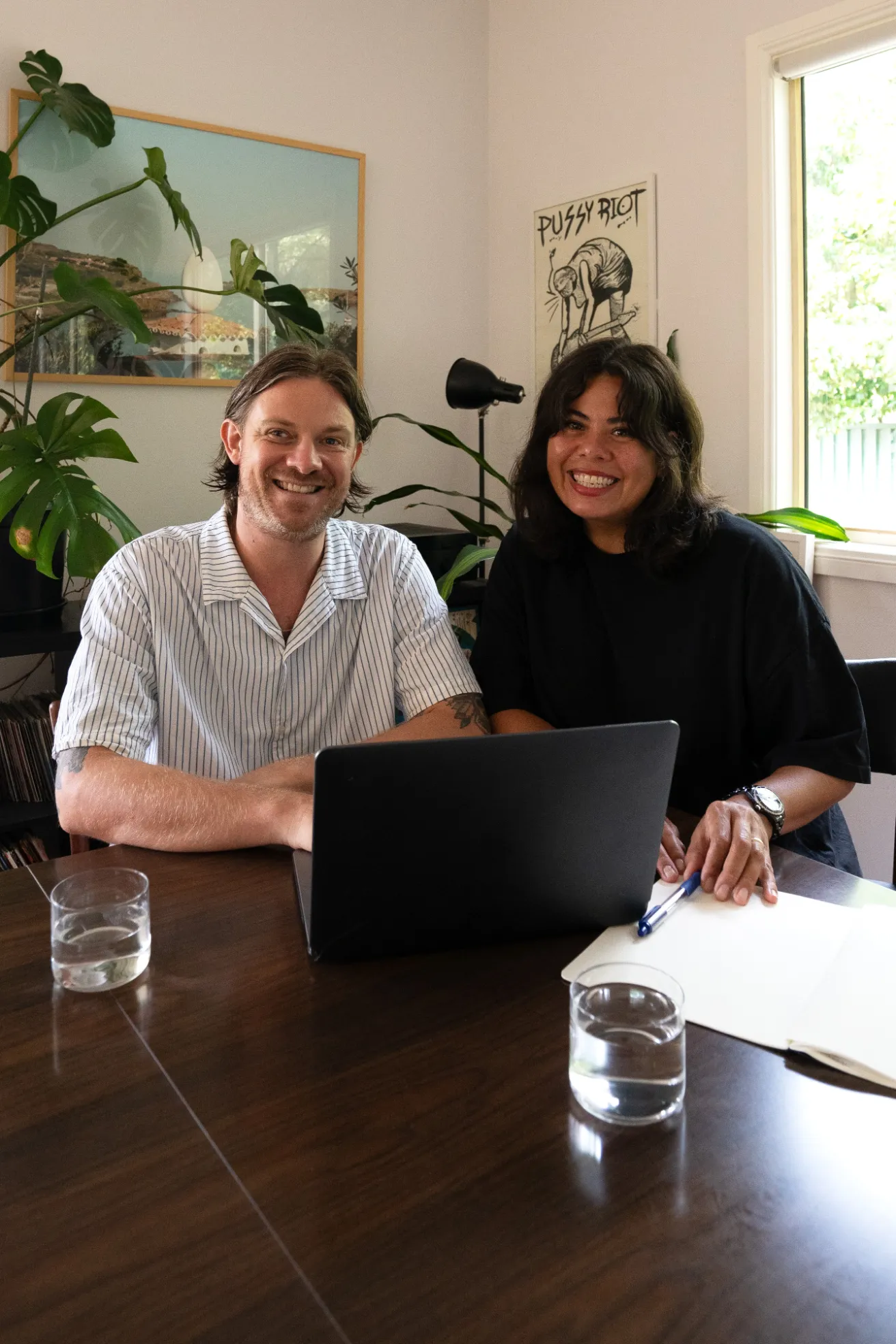 Open brand guideline booklet showing a colour palette with terracotta, blue, off white, black, and white colors, alongside social media design elements including a phone screen mockup and logo.