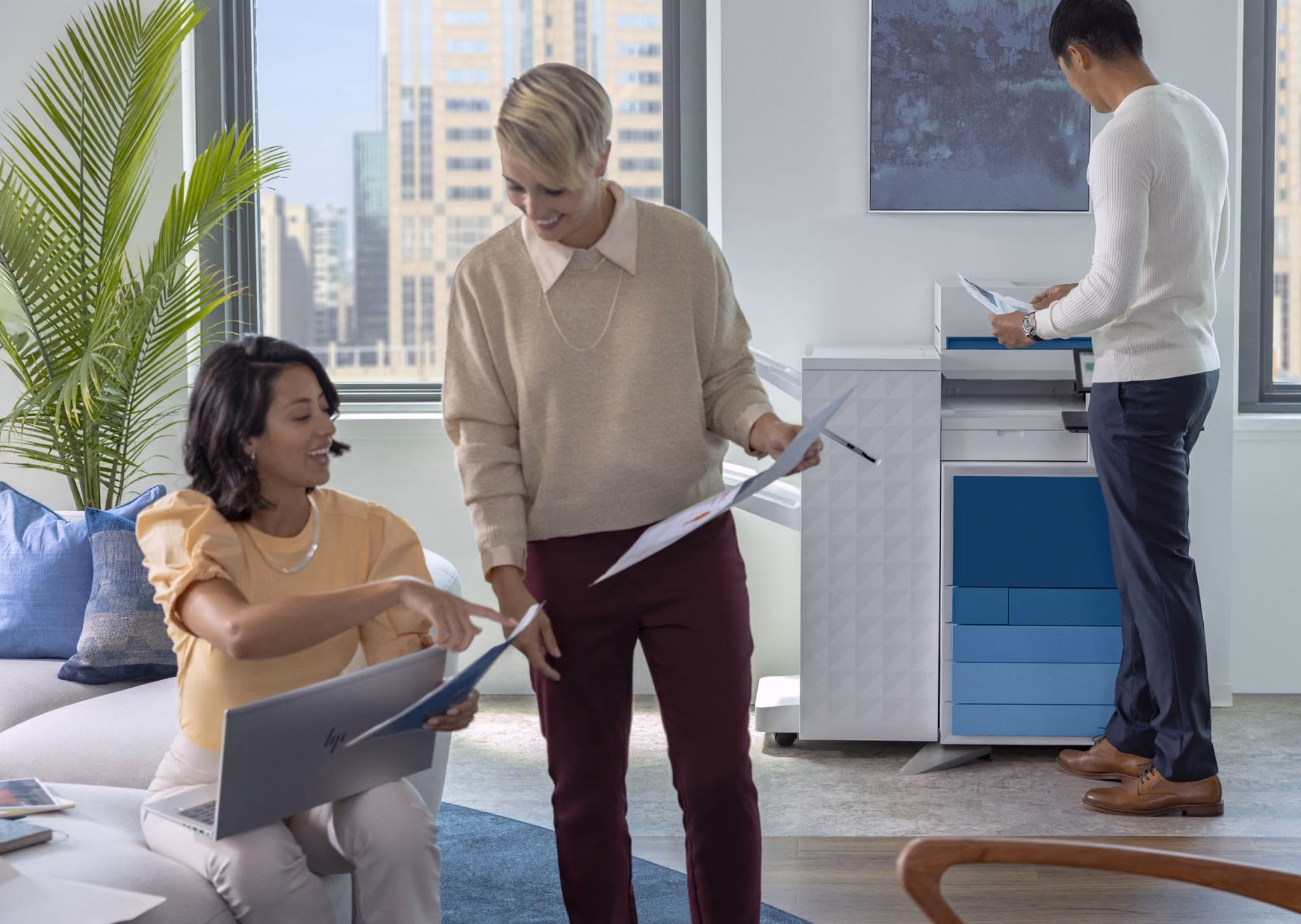Row of large office multifunction printers or copiers lined up indoors.