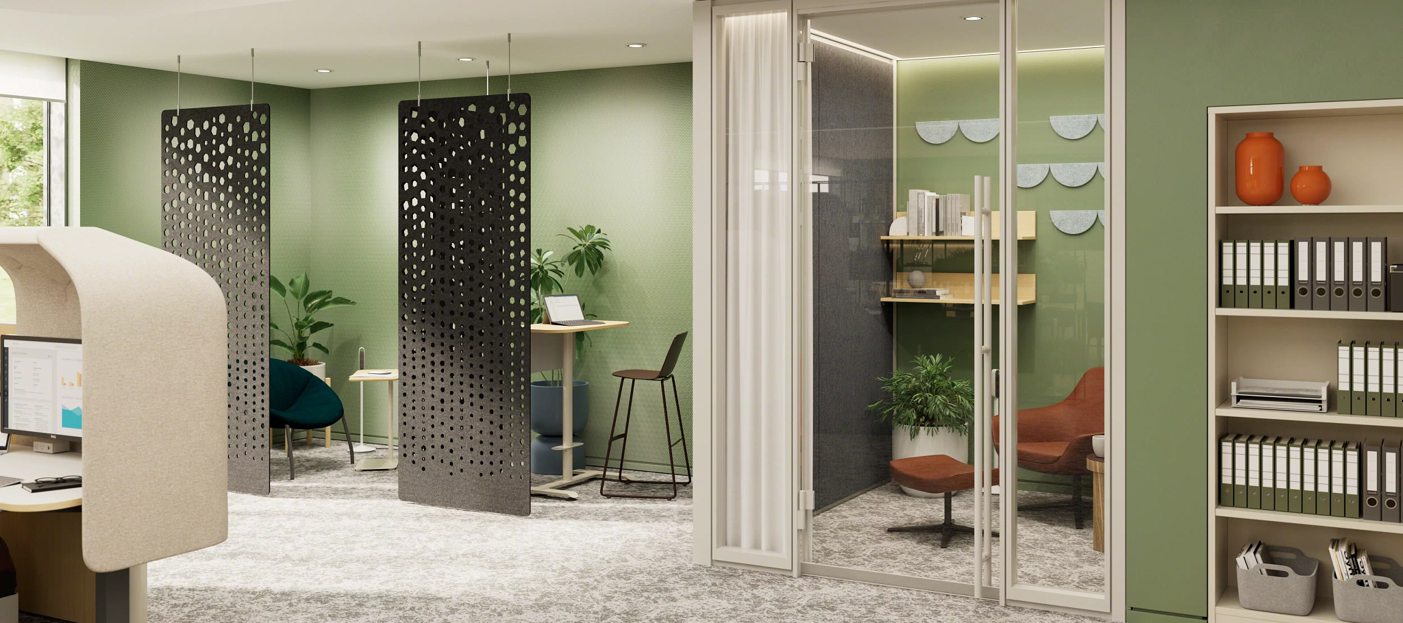 Modern office space with green walls featuring semi-private workstations with perforated gray panels, a phone booth-style glass meeting room, plants, and shelves with organized binders and orange vases.