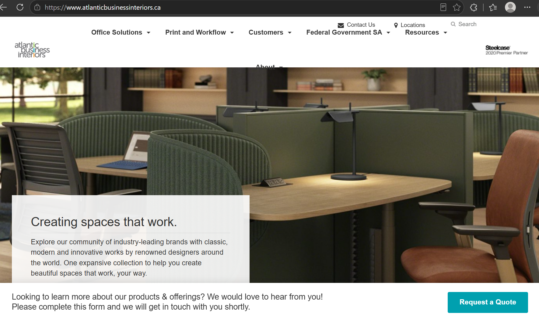 Modern office workspace with green partitions, wooden desks, chairs, laptop, and desk lamps.