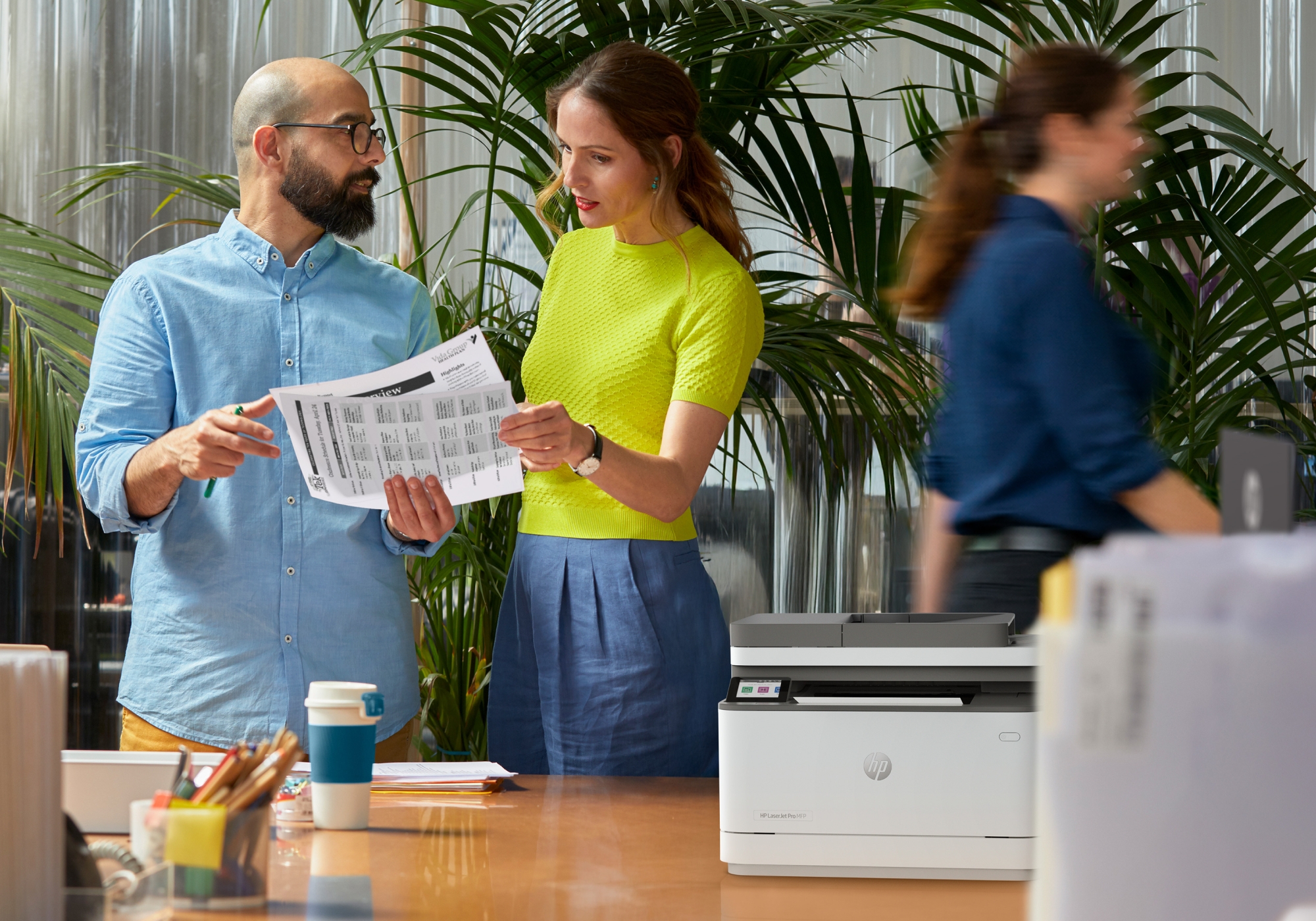 Row of large office multifunction printers or copiers lined up indoors.