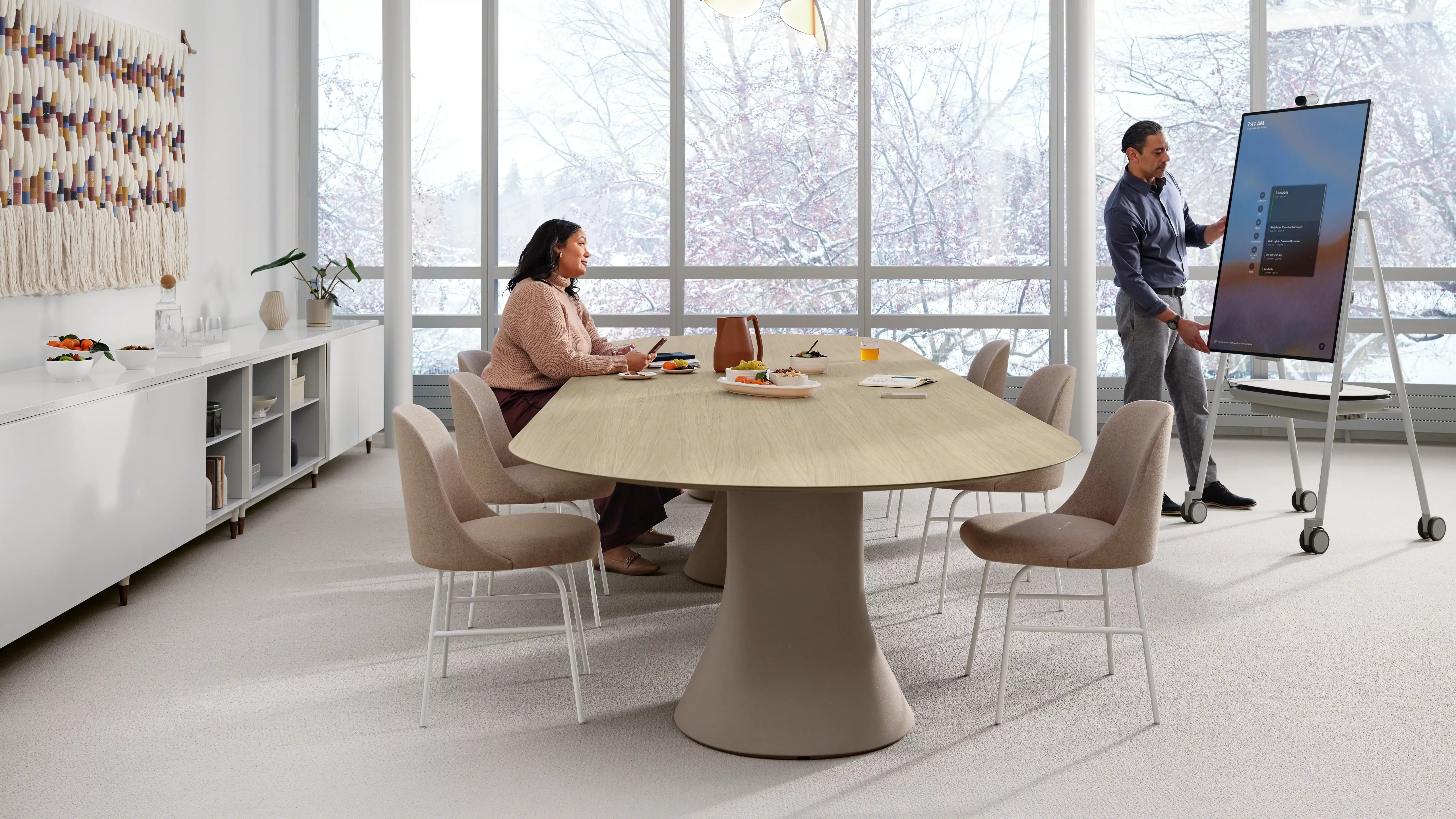 Modern working room with wooden chairs, whiteboard on wooden wall, large window, and green plant in a beige pot.