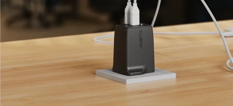 A black charging station on a wooden table.
