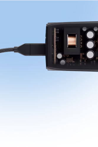 Close-up of a black electronic device with an exposed circuit board and a connected braided cable on a blue background.