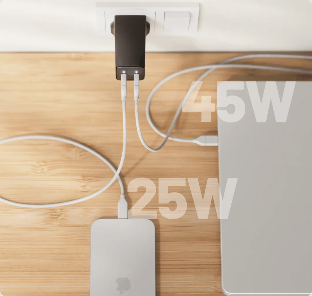 A Cuzor charger with two connected cables, one leading to a laptop and one to a phone.