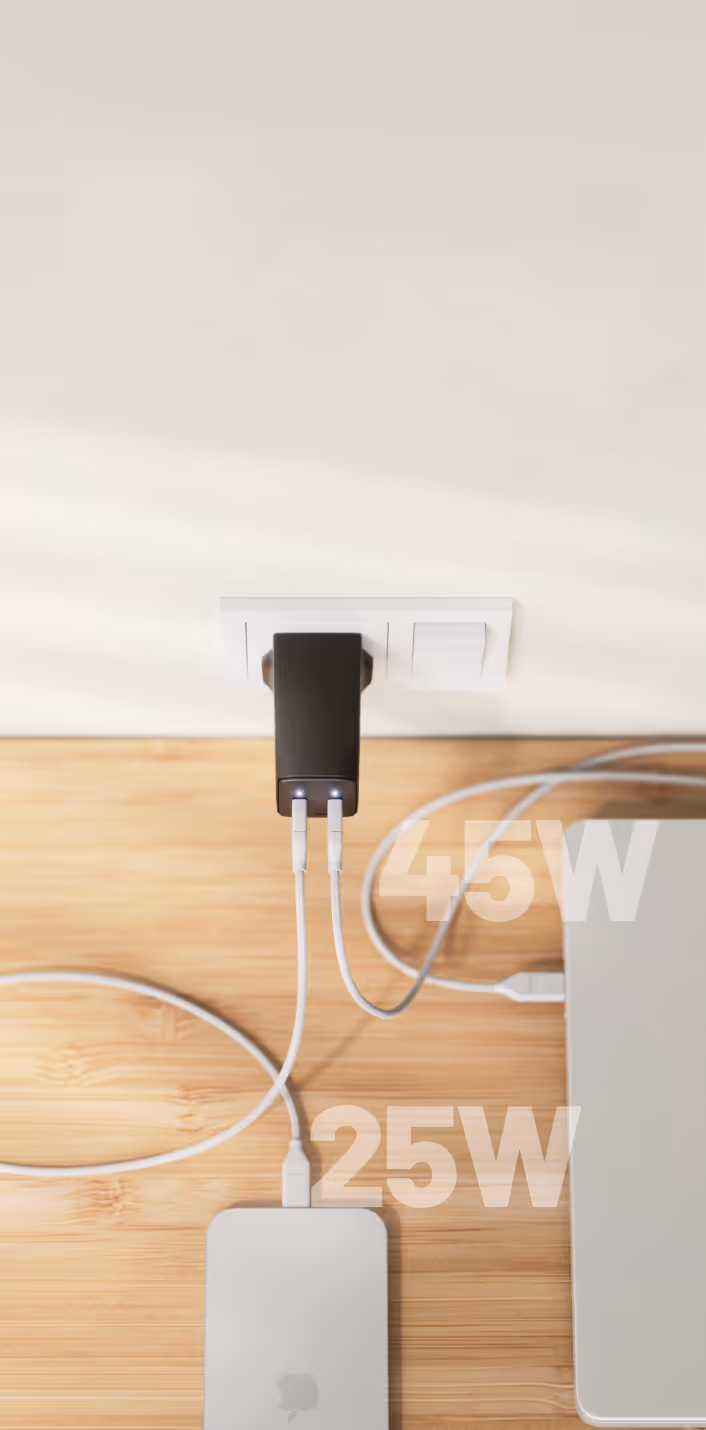 A Cuzor charger with two connected cables, one leading to a laptop and one to a phone.