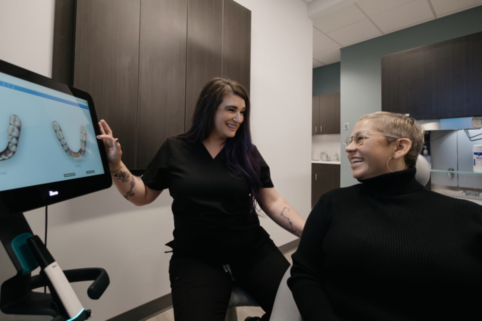 Female dentist explaining Invisalign treatment to patient at consultation