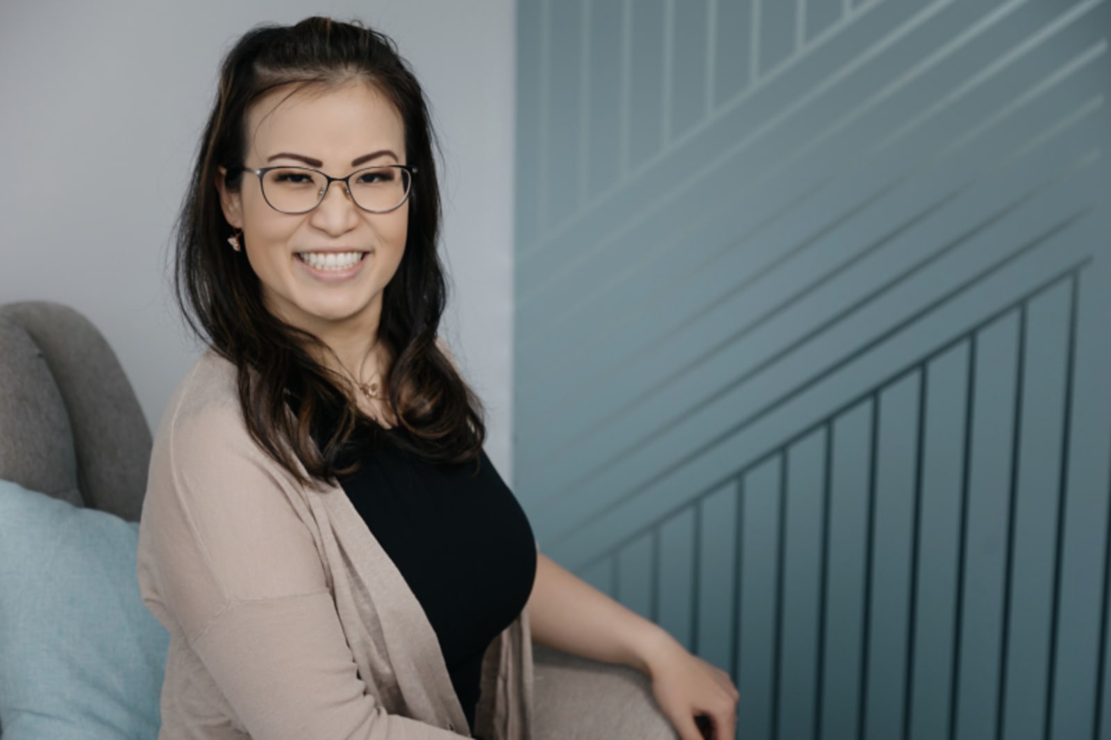 Female team member smiling while seated in modern office space