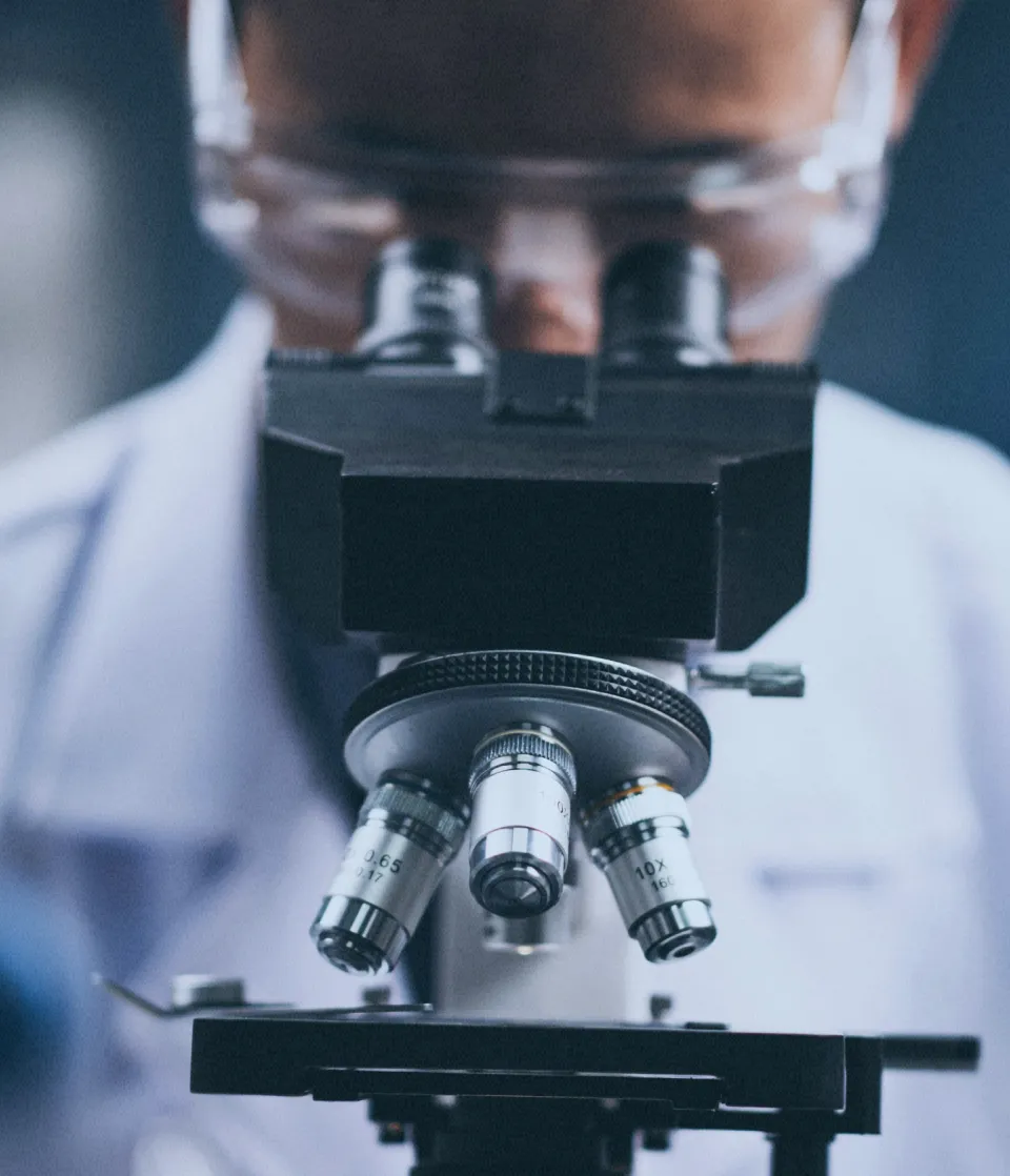 man looking into microscope