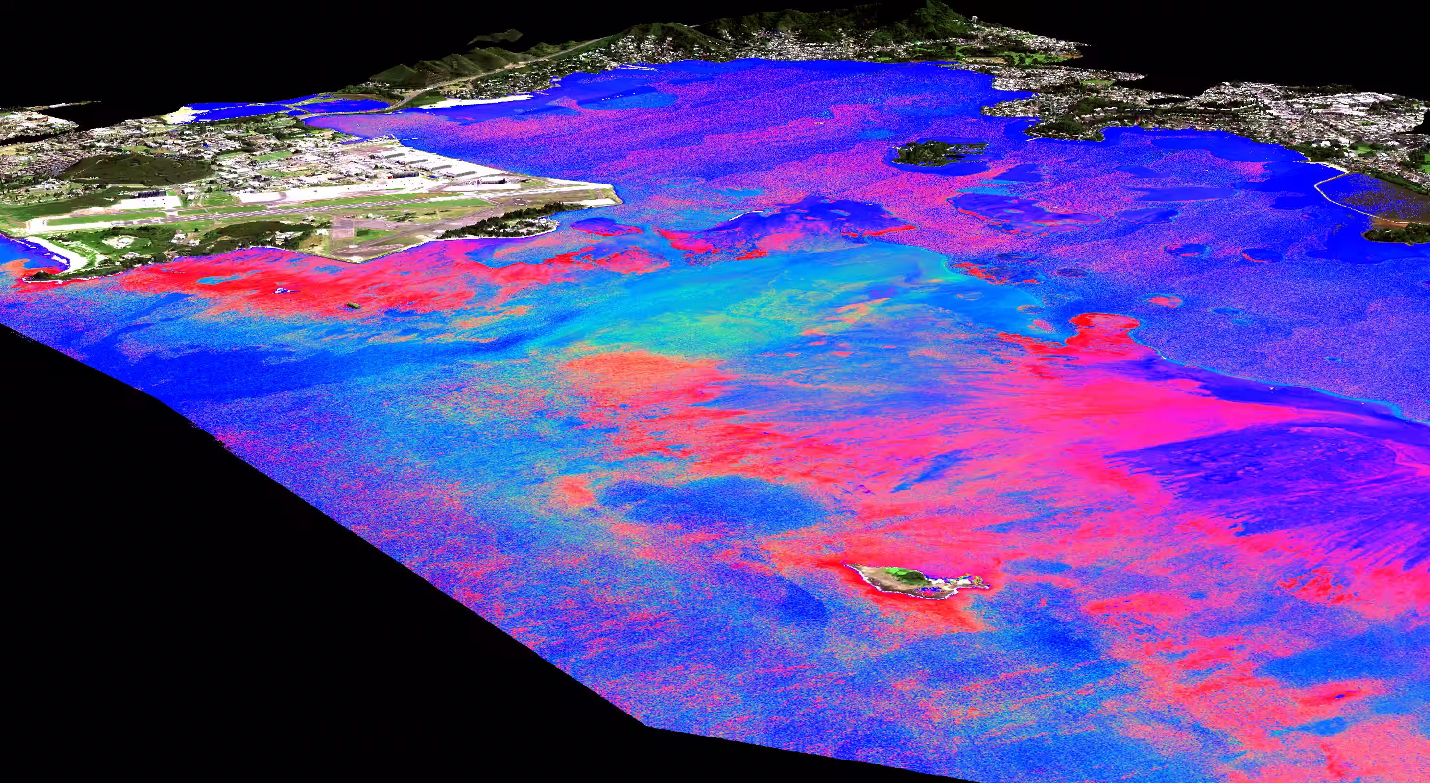 Colored satellite or aerial view of a coastal area showing land, water, and coral reef formations.