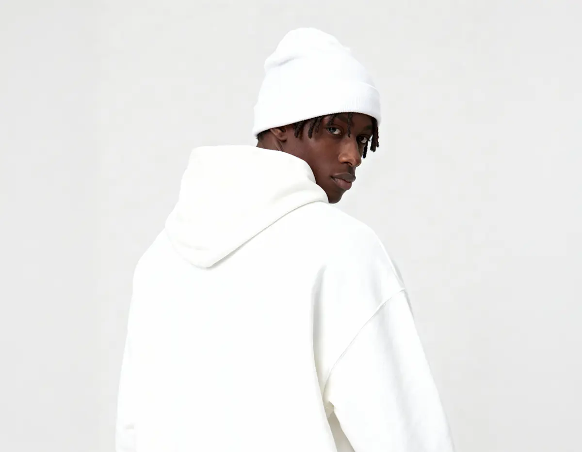 Person wearing white hoodie and bucket hat facing away.