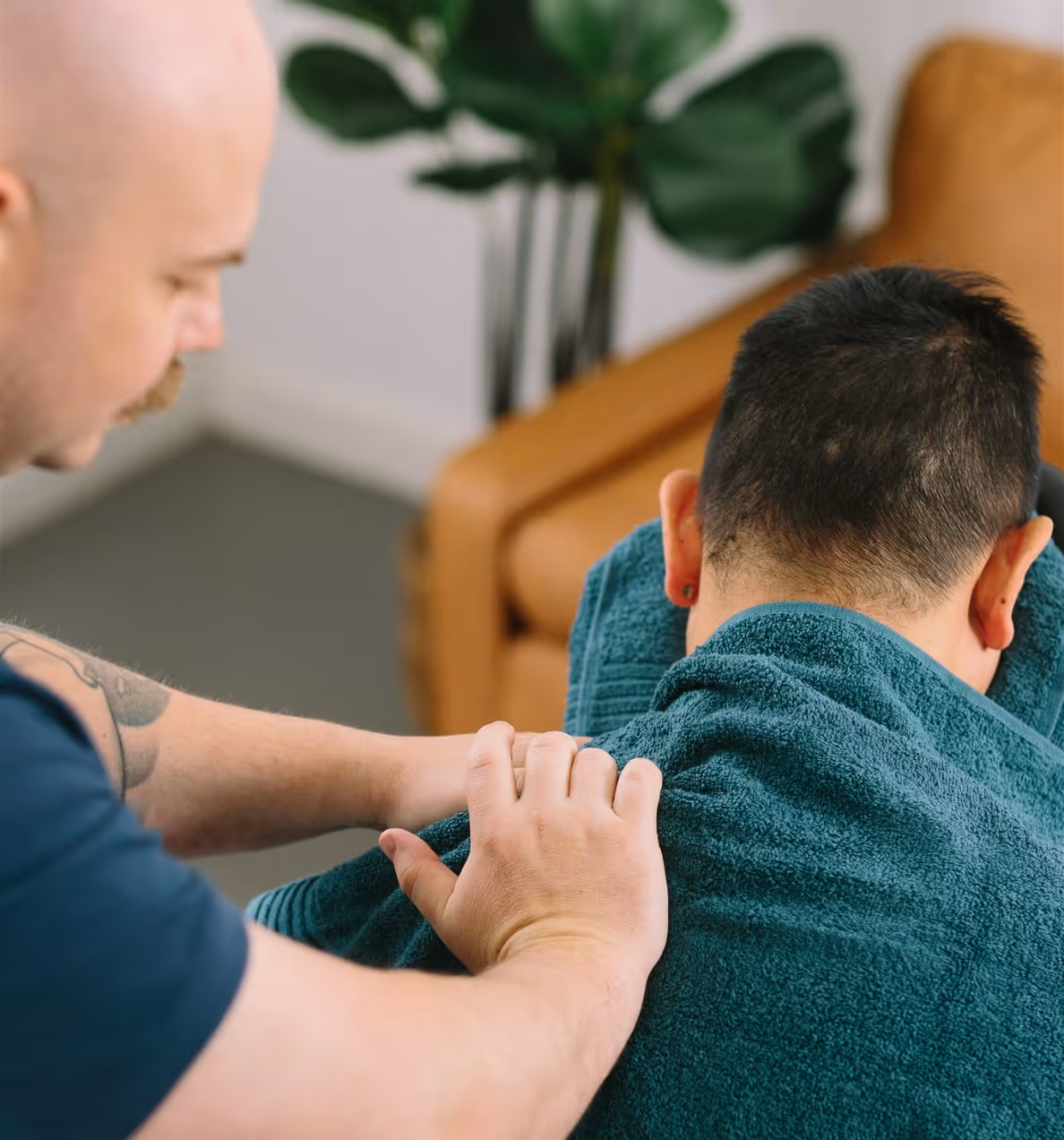 Workplace massage therapist providing on-site chair massage to a relaxed employee