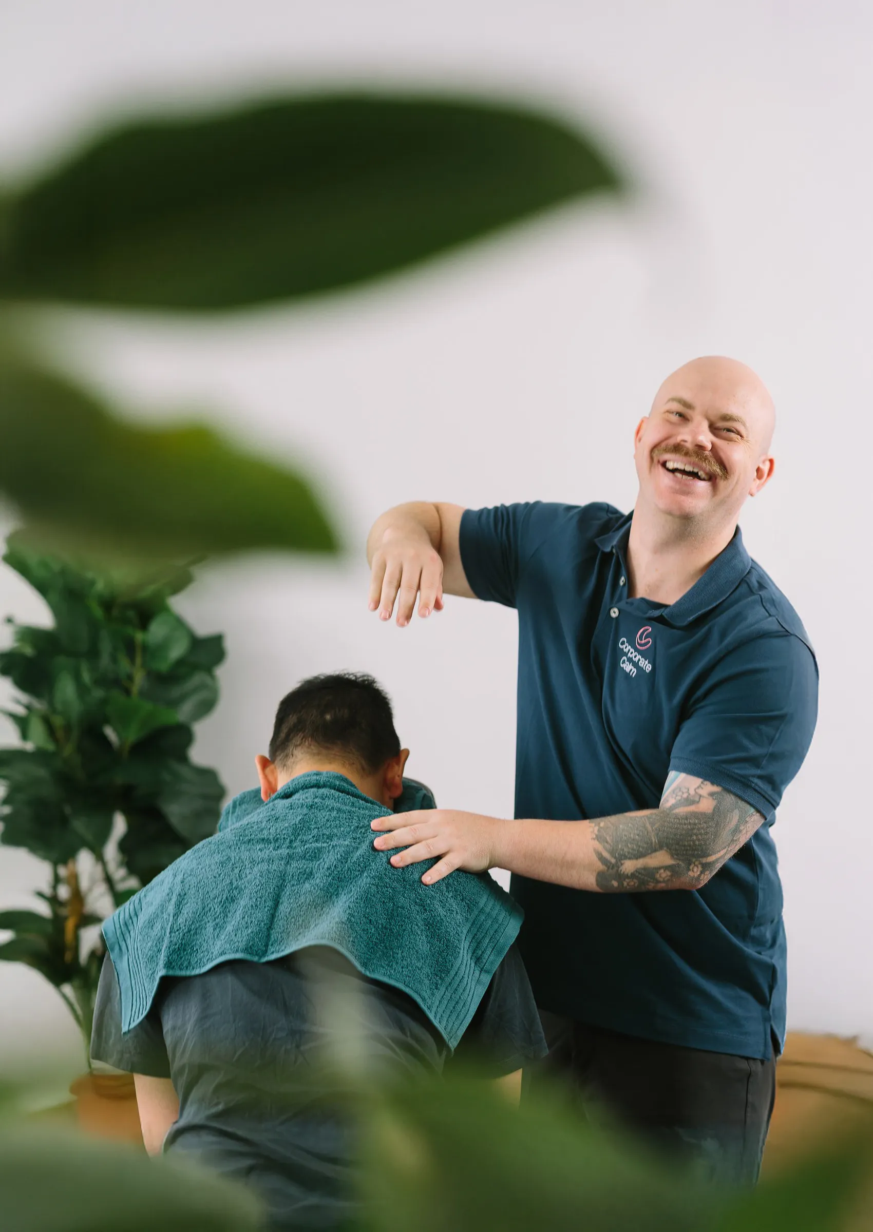 Corporate Calm therapist delivering seated workplace massage to a relaxed IT professional