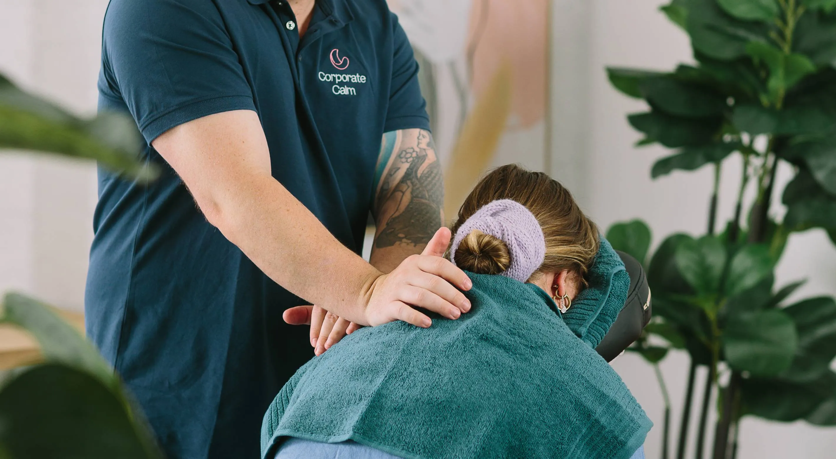 Corporate Calm event massage therapist delivering a shoulder massage to a client