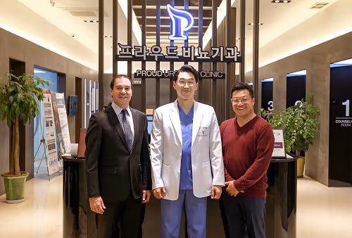 Three men standing and smiling inside a clinic lobby