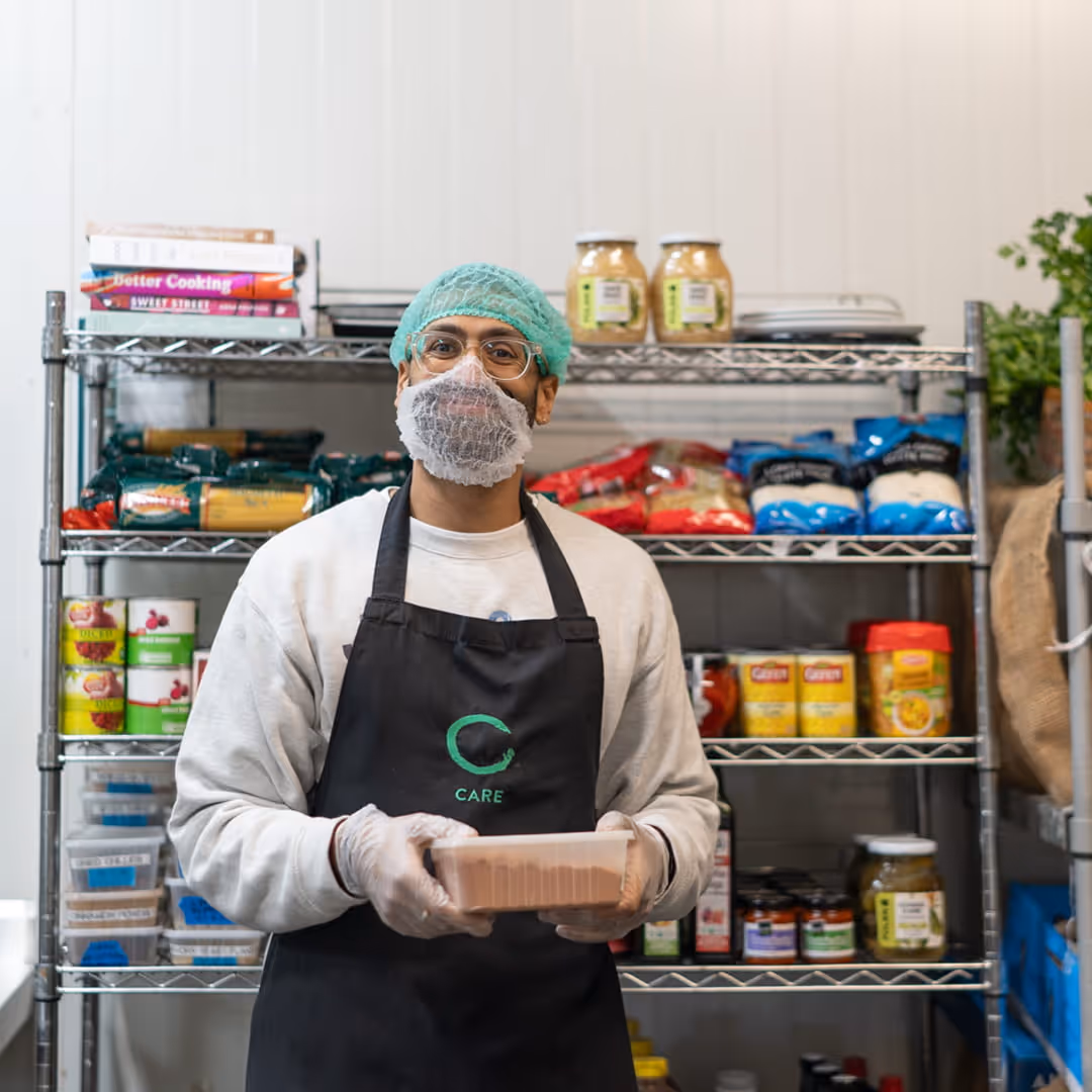 Man wearing hairnet, holding food container