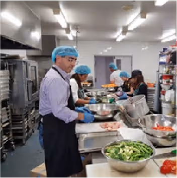 Man wearing a hairnet volunteering in kitchen