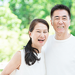 Smiling Korean couple enjoying time together outside, feeling grateful after a successful morning of trading.