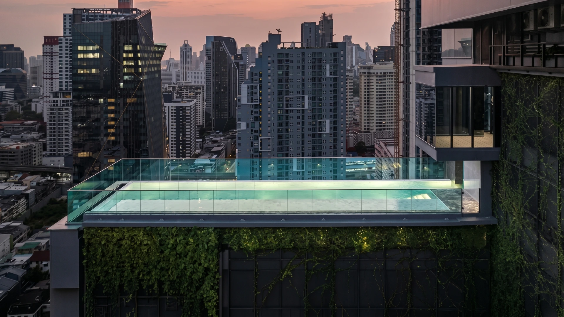 สระว่ายน้ำกระจกบนดาดฟ้าคอนโดติดรถไฟฟ้า พร้อมวิว skyline กรุงเทพฯ ยามพระอาทิตย์ตก