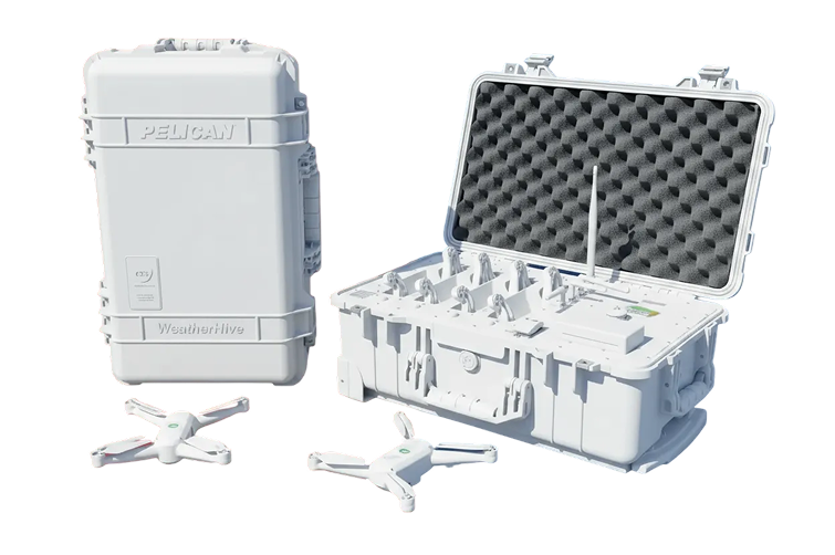 White rugged Pelican WeatherHive case closed beside an open weather monitoring device case with foam padding and white multi-rotor drones.
