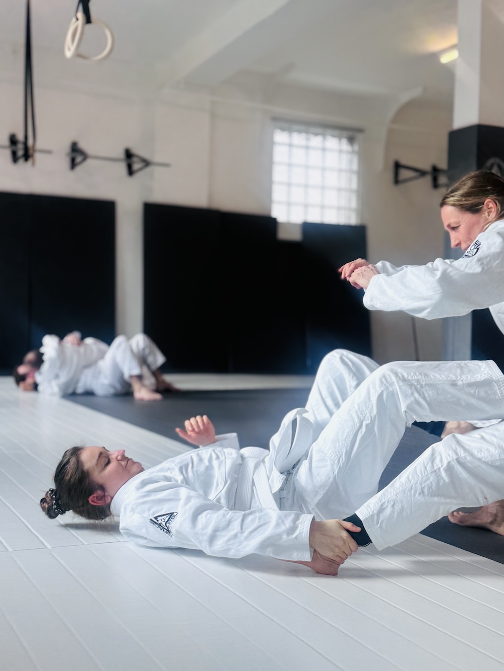 Smiling young woman with long curly black hair posing against a beige background.