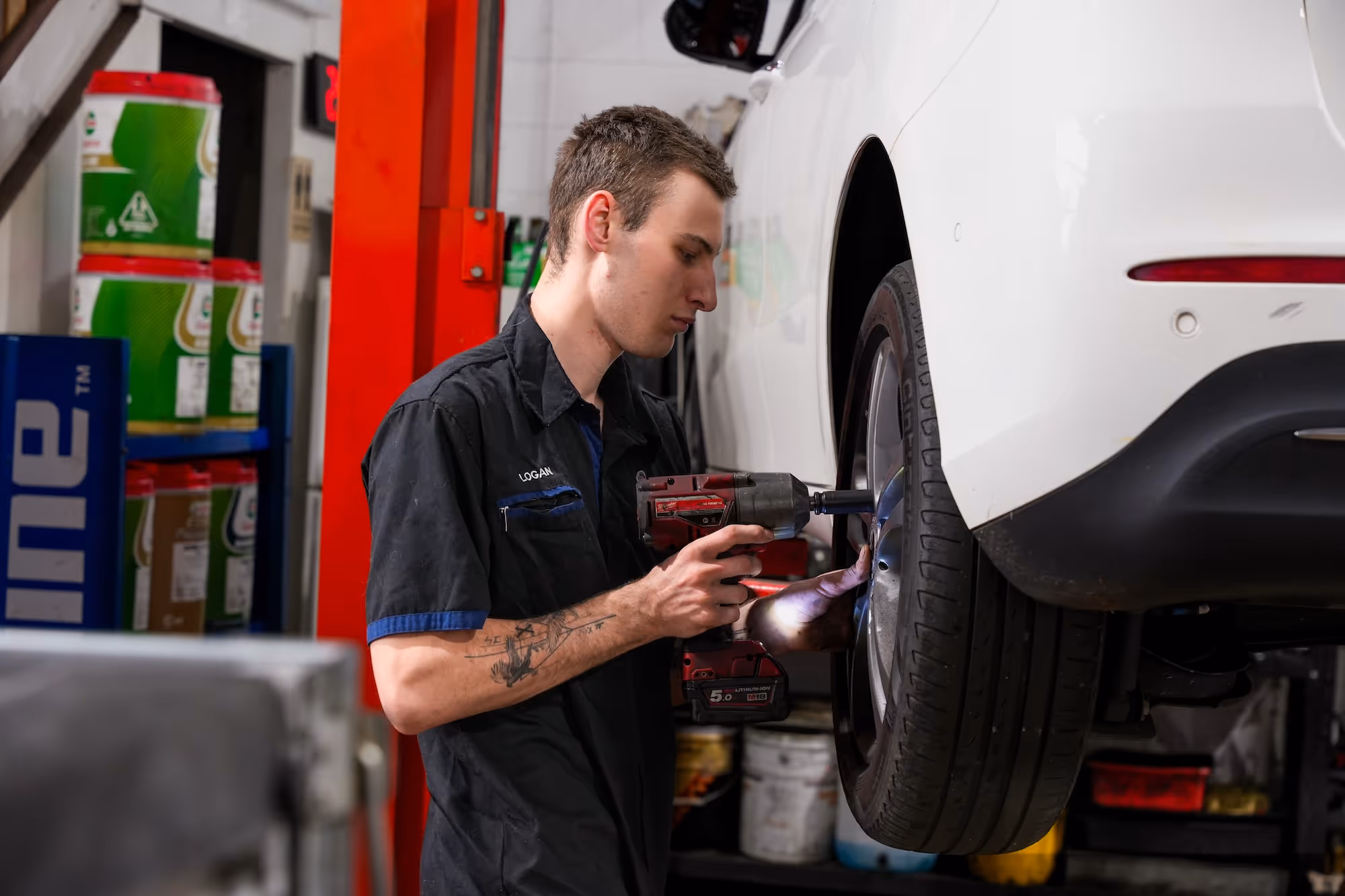 Pearson Automotive mechanic using an impact wrench on a car wheel in the Milton workshop.