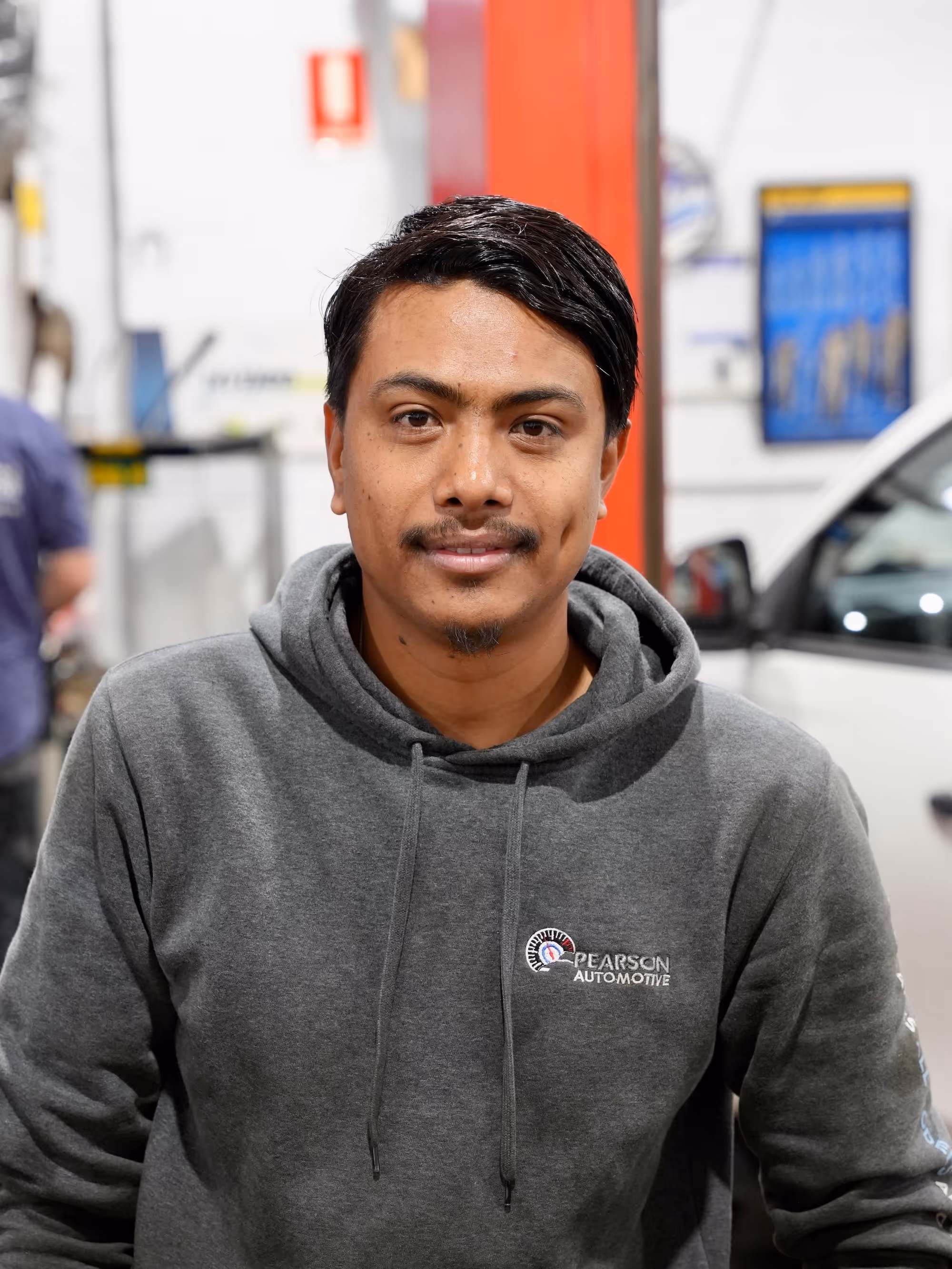 Young Pearson Automotive team member wearing a black branded jacket, representing the reliable service team in Milton.