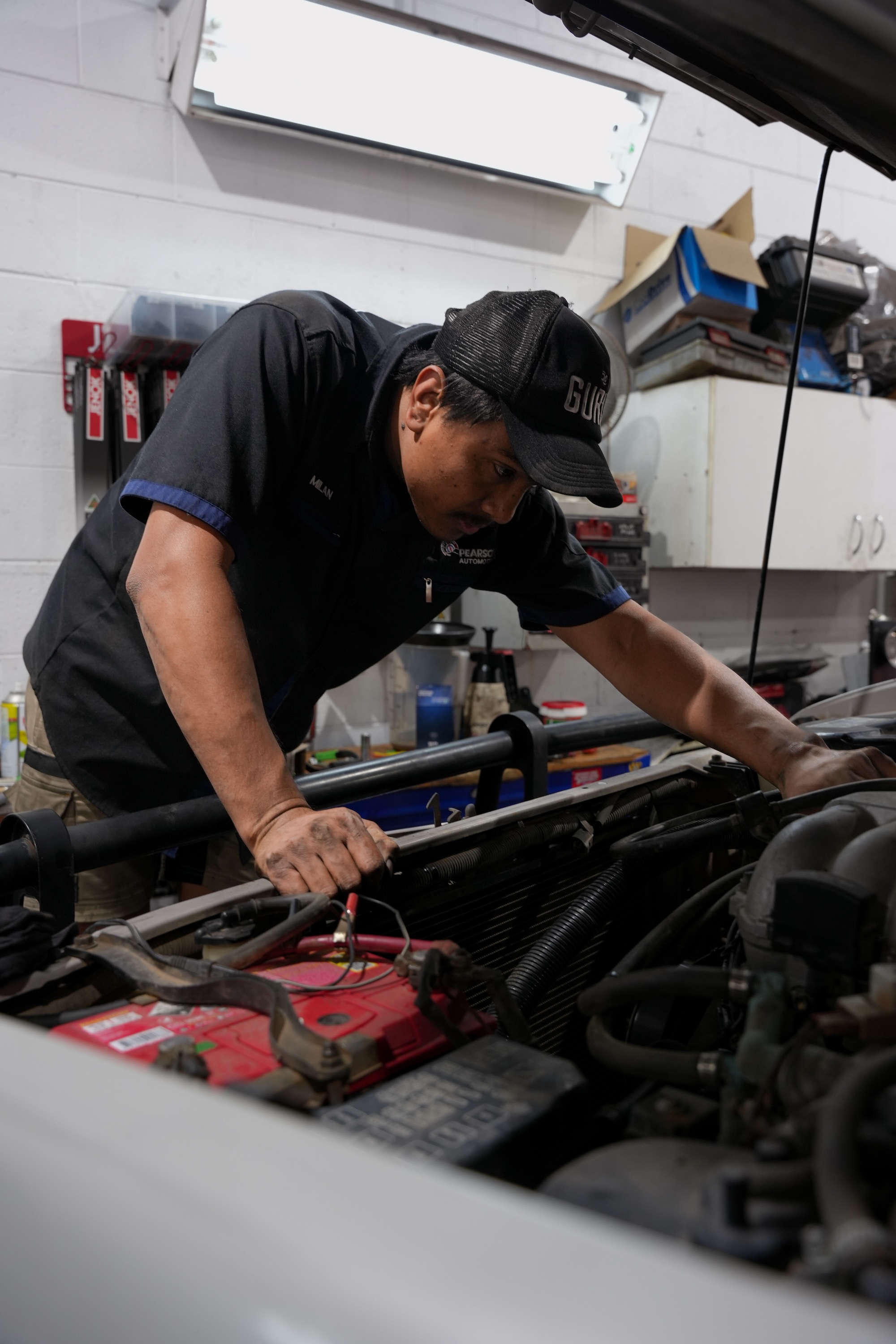 A Pearson Automotive mechanic completing a detailed logbook service checklist to maintain manufacturer warranty.