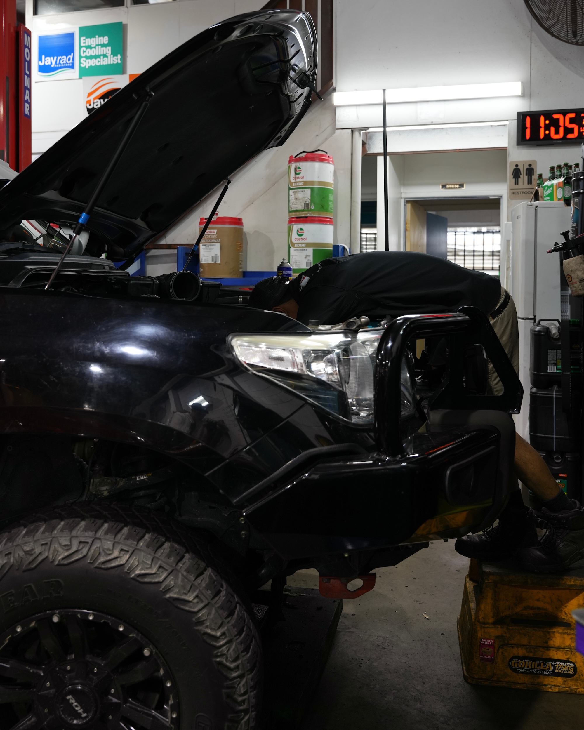 Mechanic performing a pre-trip safety check on a 4WD SUV in the Pearson Automotive workshop, ensuring it is ready for off-road or highway driving.