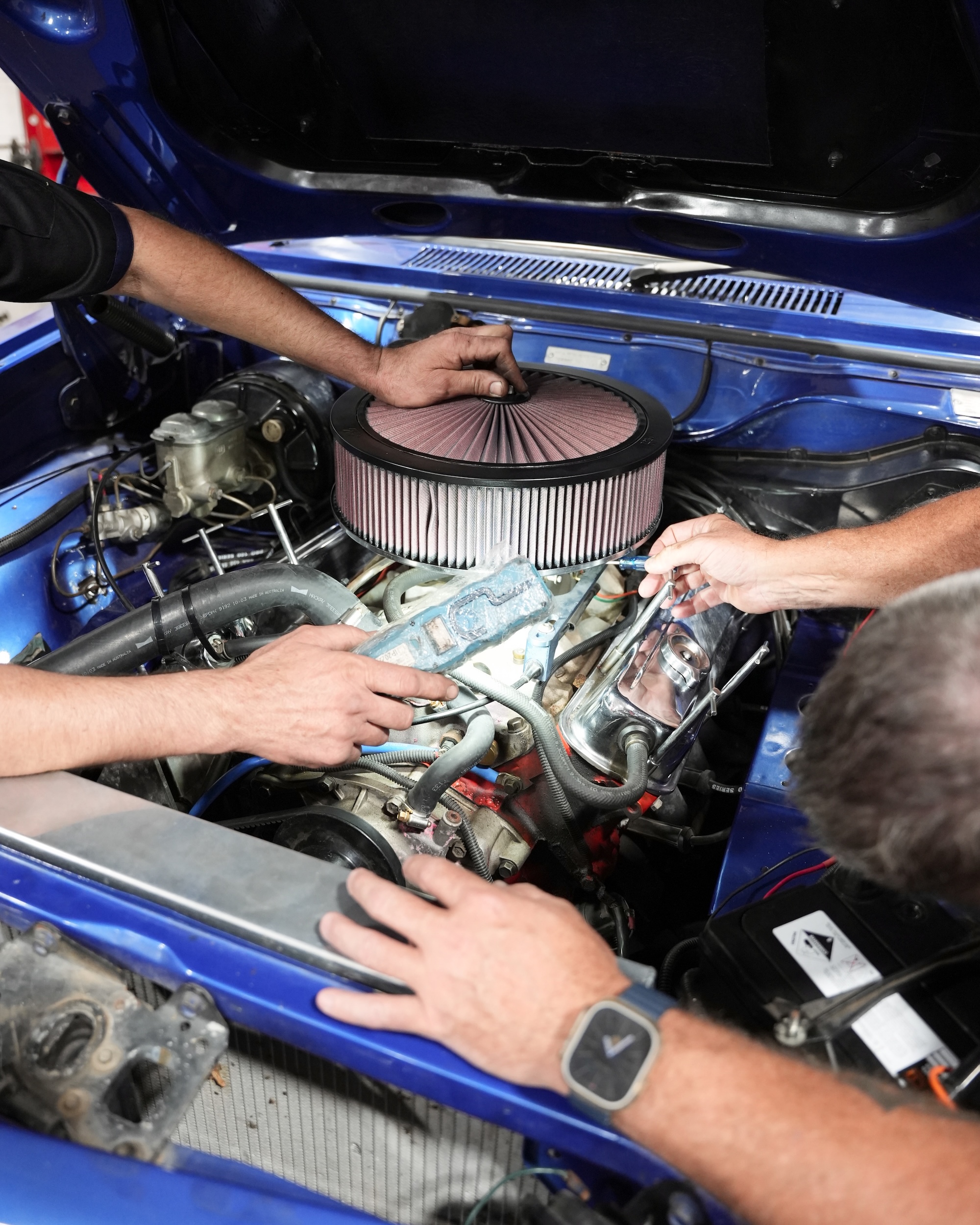 Close-up of skilled mechanic hands performing detailed engine maintenance and intake system tuning to ensure optimal performance.