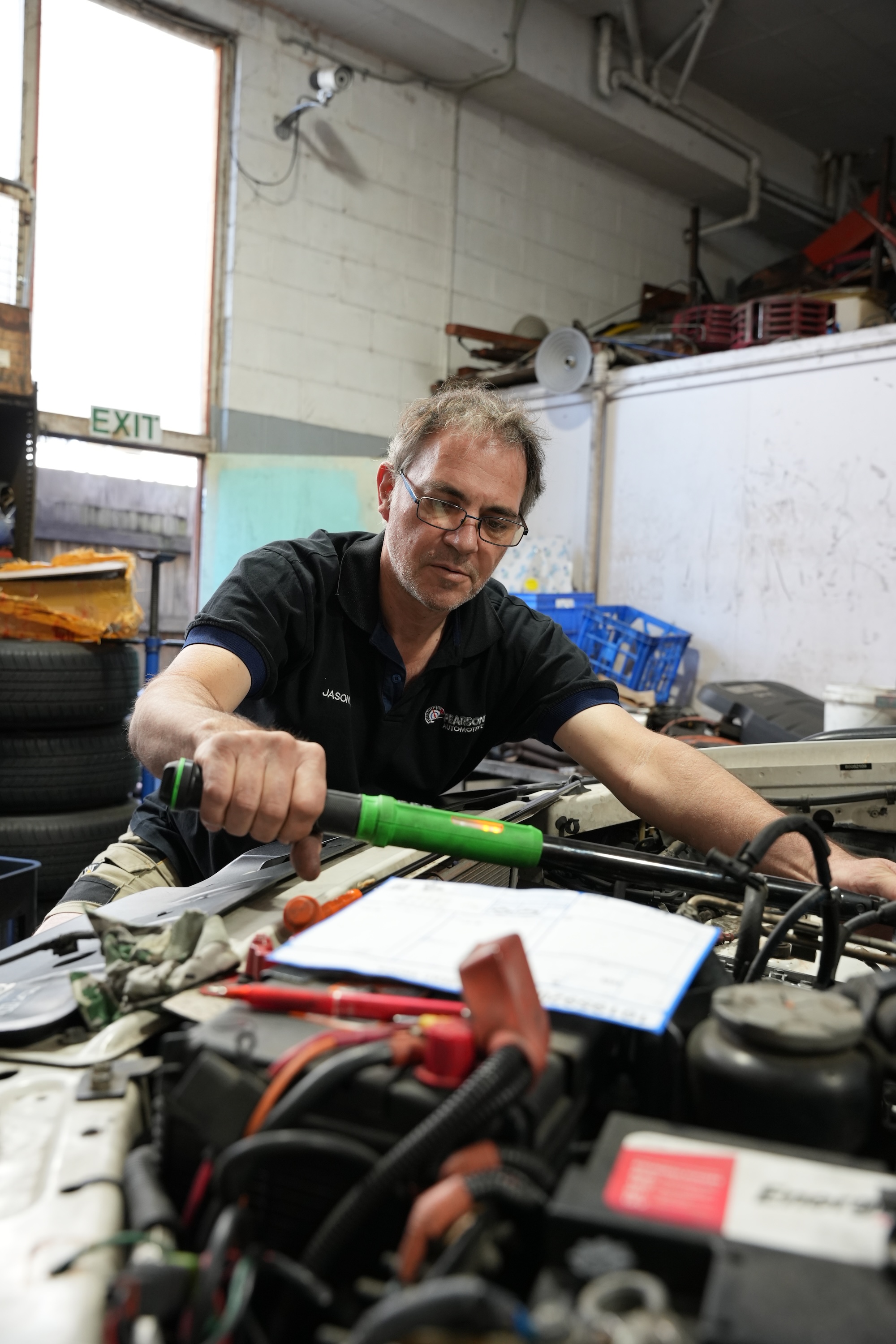 Experienced mechanic performing a hands-on engine diagnostic check to identify mechanical faults and verify scan tool data.