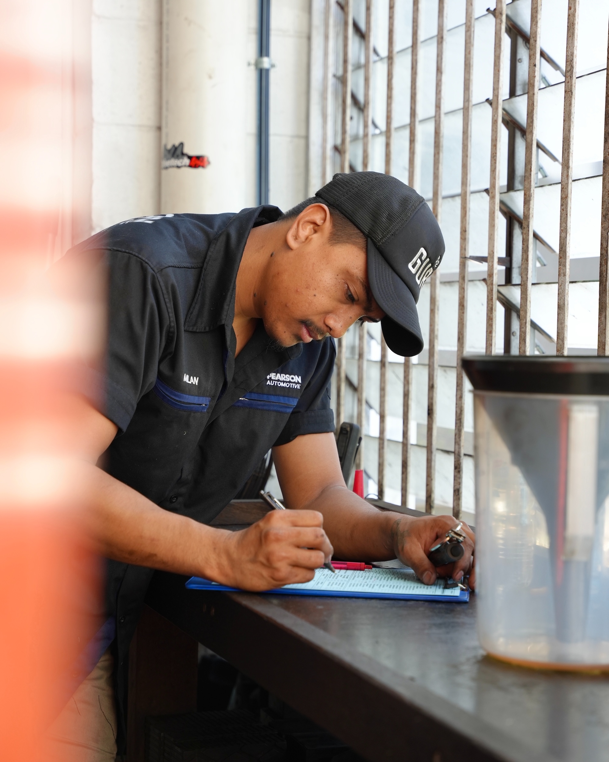 A mechanic performing a thorough engine and battery inspection as part of a logbook service in Milton.