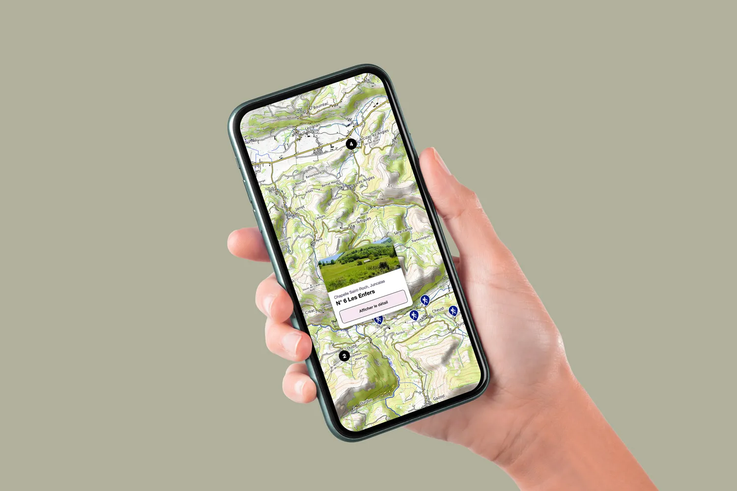 Main view smartphone held displaying a hiking trail map with marked routes and points of interest.