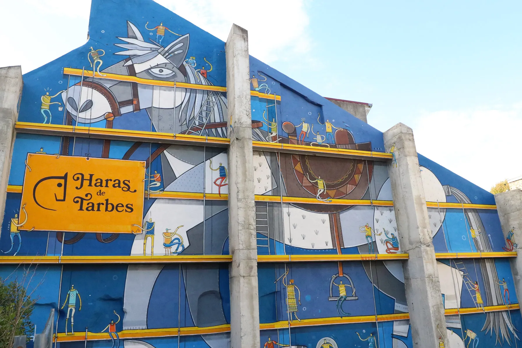 Fresque murale colorée représentant un cheval stylisé avec des petits personnages sur des échafaudages.