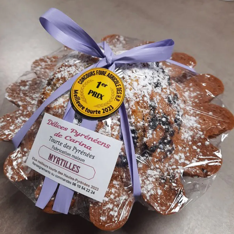 Tourte des Pyrénées aux myrtilles emballée avec un ruban violet et médaille 1er prix 2023.
