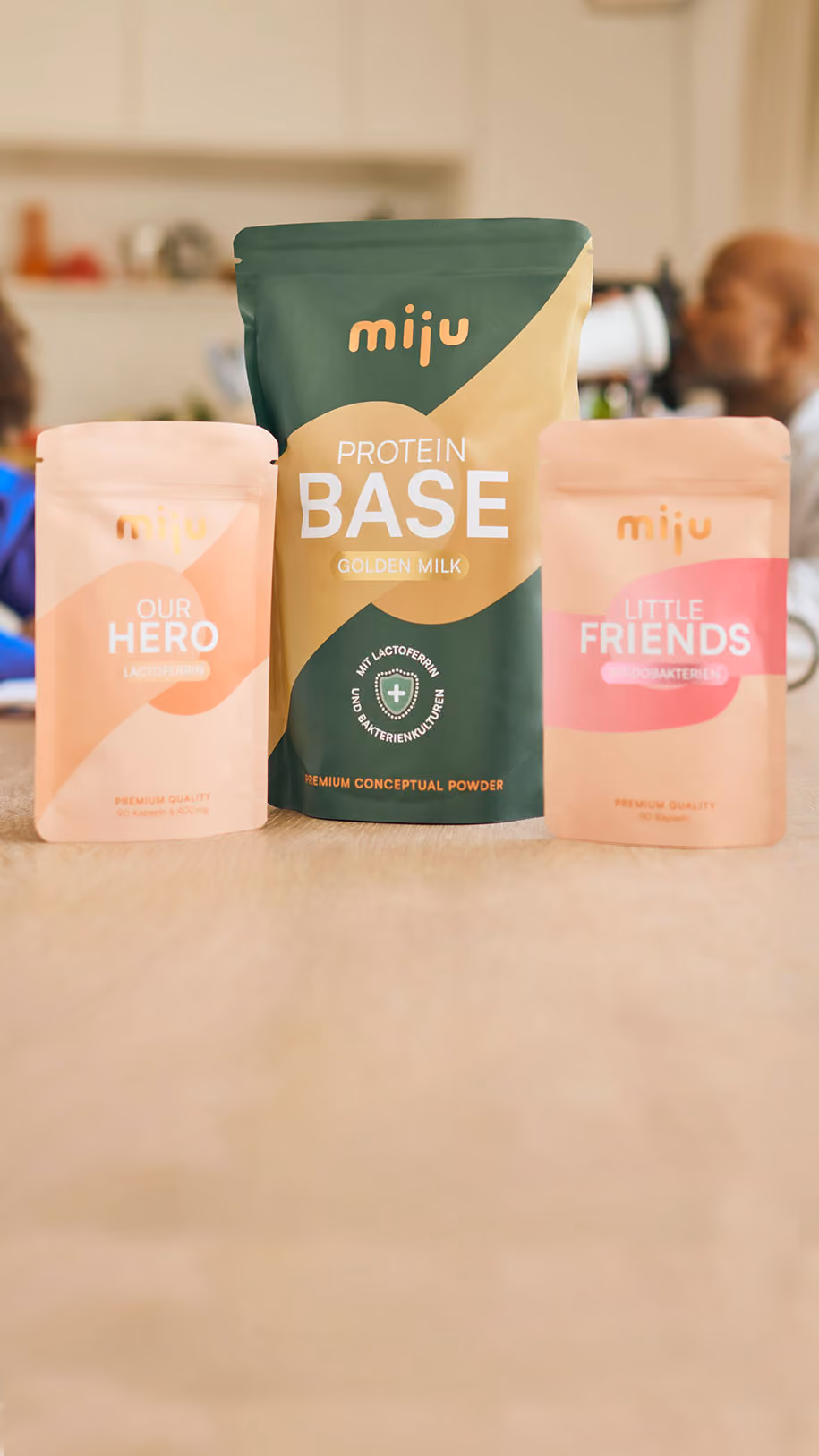 miju Lactoferrin, Bifidobakterien und Proteinpulver vor einer Familie im Alltag. Im Hintergrund trinkt ein Vater einen Proteinshake, während eine Großmutter gemeinsam mit ihrem Enkel lacht.