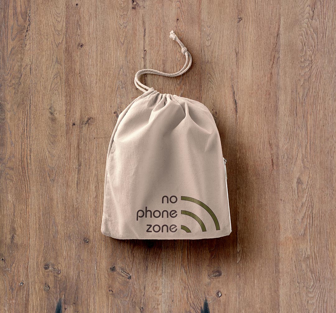 A No Phone Zone bag laid on a wooden floor