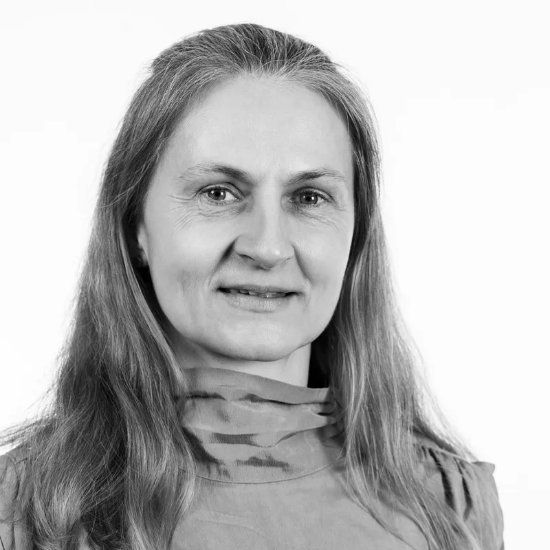Smiling middle-aged man with short hair wearing a casual shirt against a plain background.