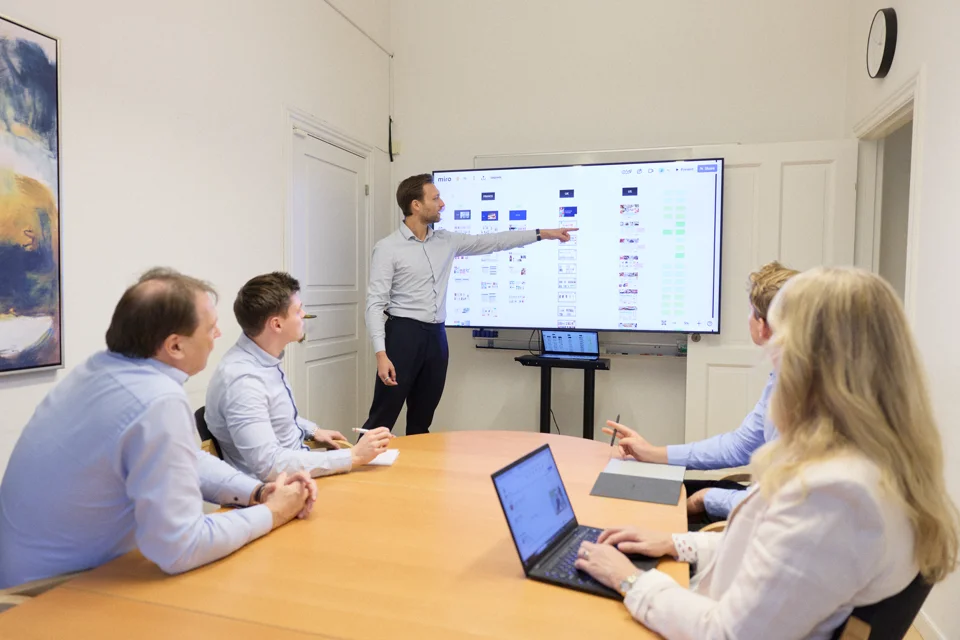 Man in a blue shirt holding a red Ferrari sports car model in his hands.
