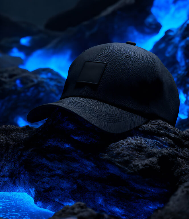 Black baseball cap resting on dark rocky surface with glowing blue light illuminating the background.