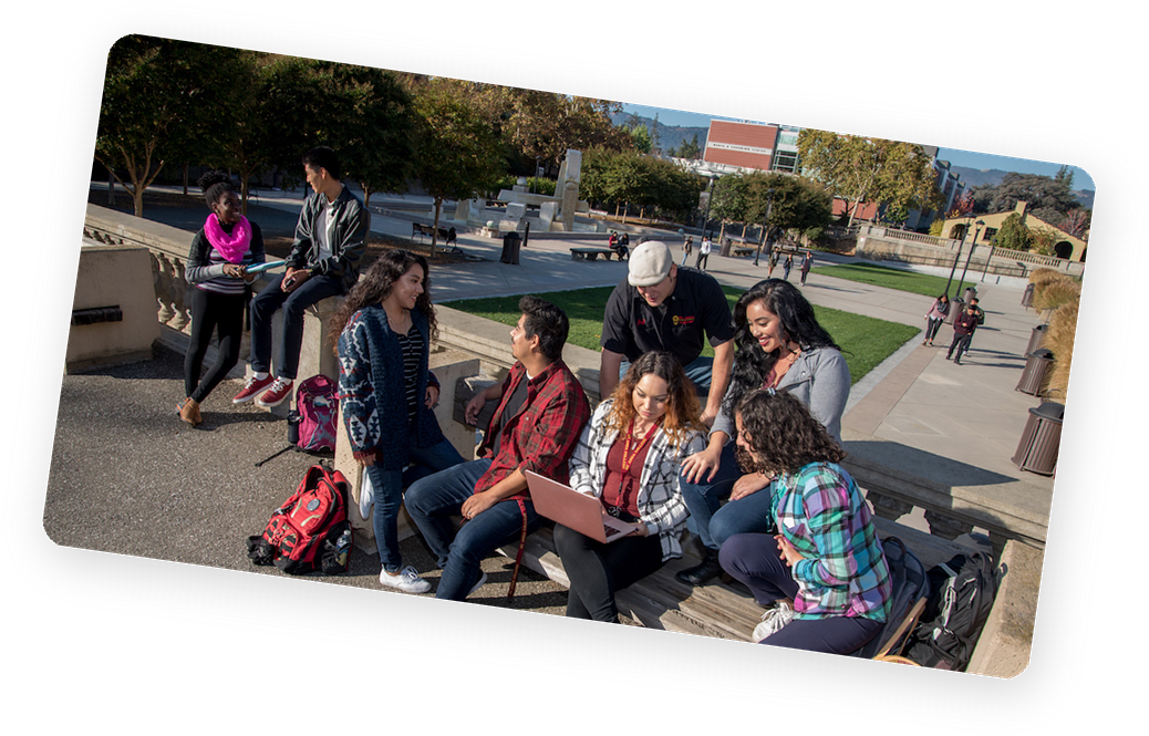 Students socializing outdoors on a college campus quad