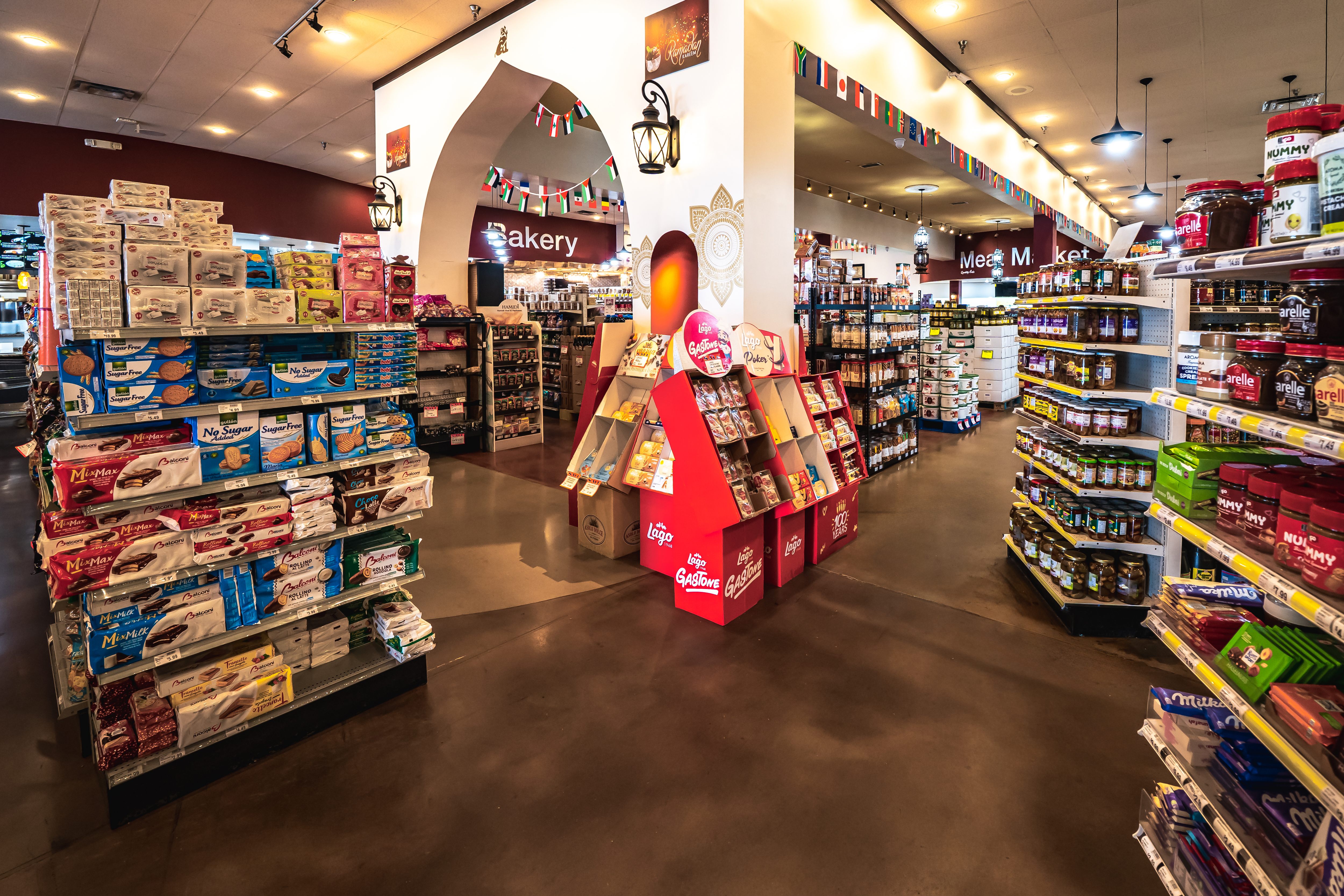 A supermarket aisle lined with shelves stocked with a variety of packaged spices, condiments, and biscuits.