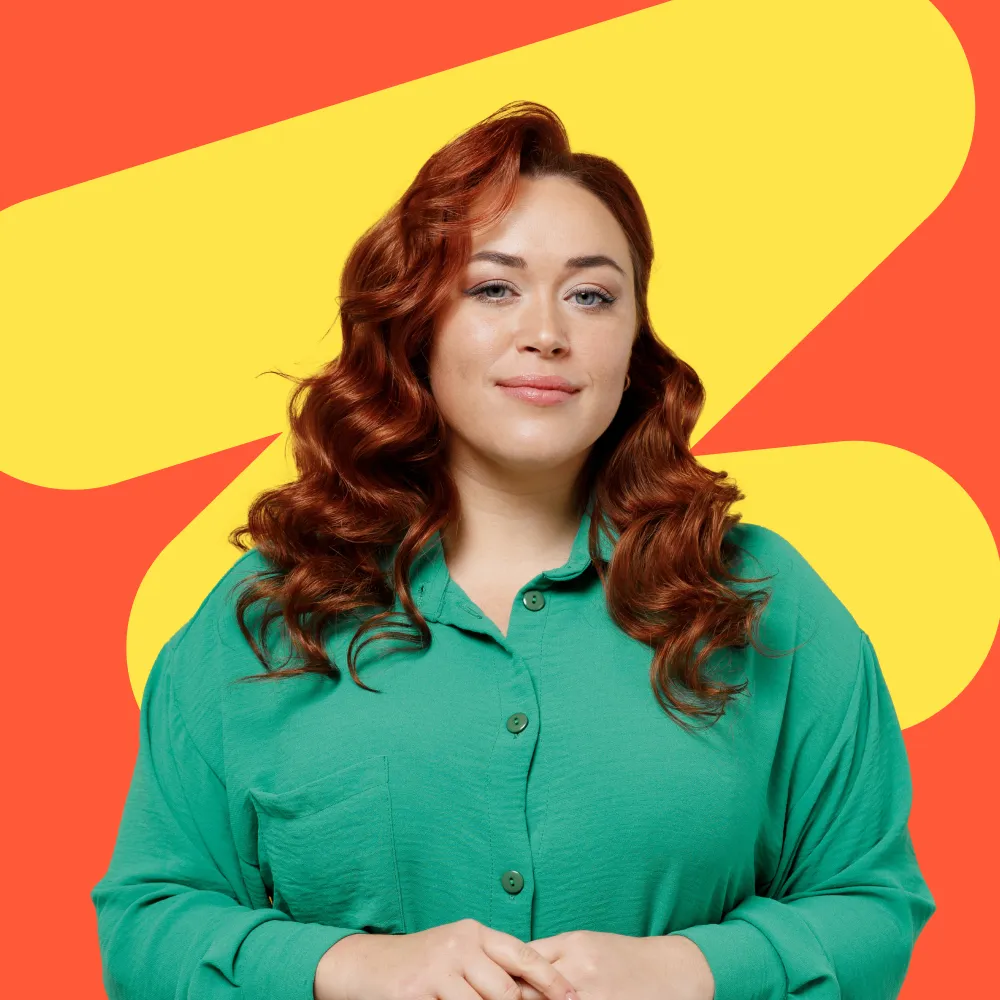 A woman in a green shirt standing with her arms crossed.